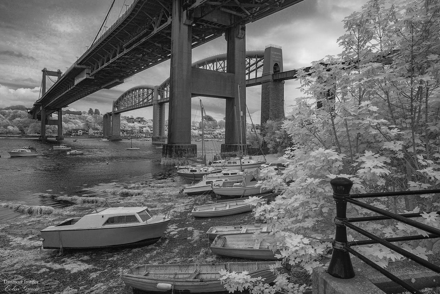 Low tide on the River Tamar leaves small boats high and dry under the road and rail bridges that span the river between Devon and Cornwall.