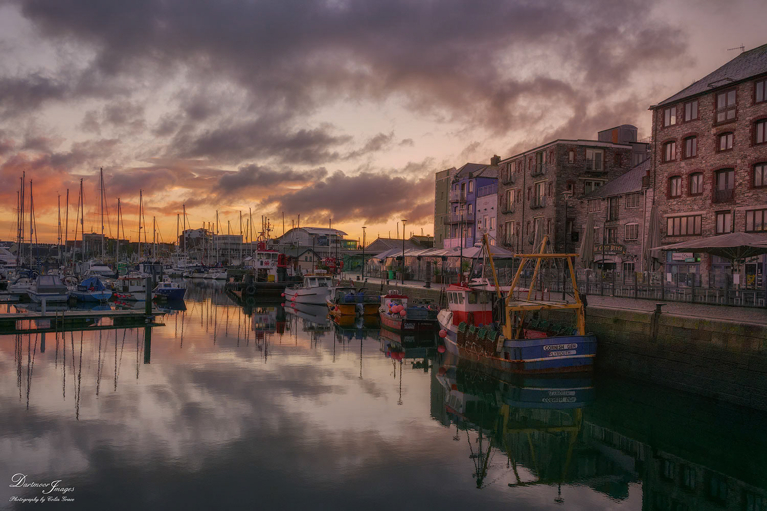 An early morning on The Barbican in Plymouth finds fishing boats and other small craft sitting idly at their moorings as the first light of the rising suns adds a bit of colour to the cloudy sky.