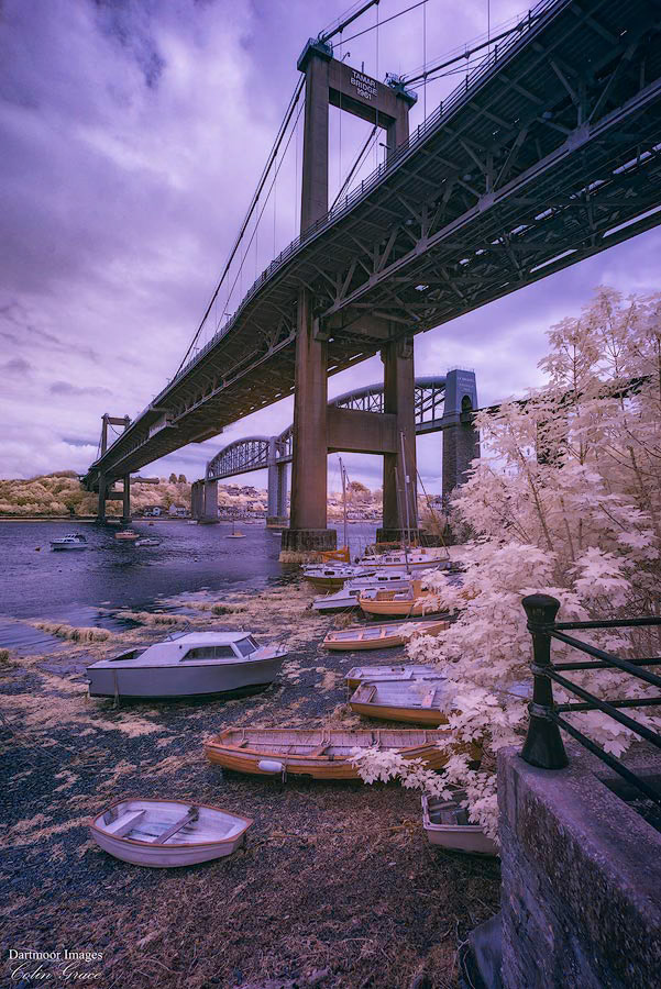 Low tide on the River Tamar leaves small boats high and dry under the road and rail bridges that span the river between Devon and Cornwall.