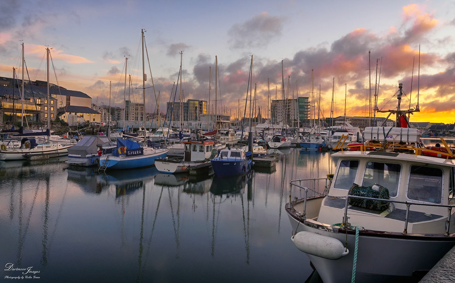 Boats and yachts sit idle at their moorings in Sutton Harbour as the sun rises over Plymouth.