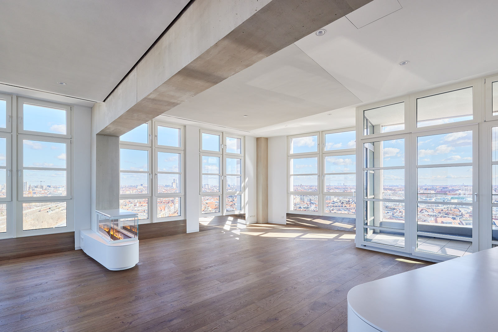 Großzügiger Wohnraum im Wohnturm High West mit Panoramafenstern und offenem Grundriss über den Dächern Berlins.