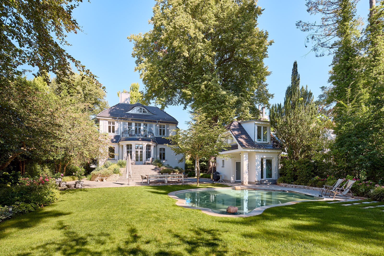 Großzügige Villa mit parkartigem Garten, Wasserbezug und weitläufiger Rasenfläche.