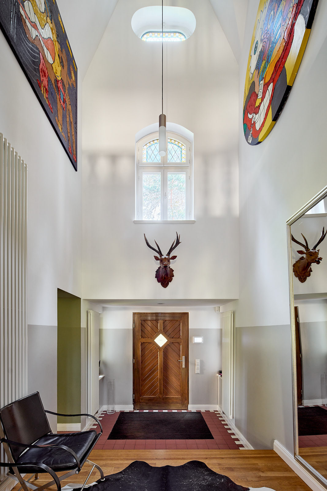 Heller Innenraum des historischen Torhauses in Berlin-Wannsee mit zeitgenössischer Kunst und offener Raumgestaltung.
