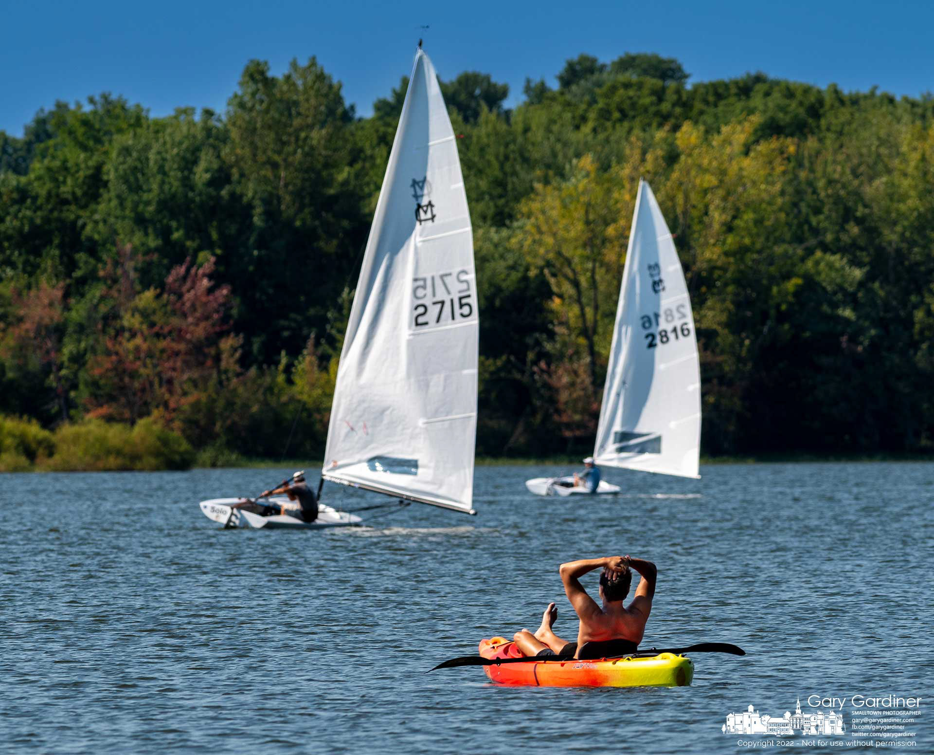 A kayaker leans back with his hands behind his head watching sailboats travel along the racecourse between buoys at the Hoover Sailing Club. My Final Photo for August 28, 2022.
