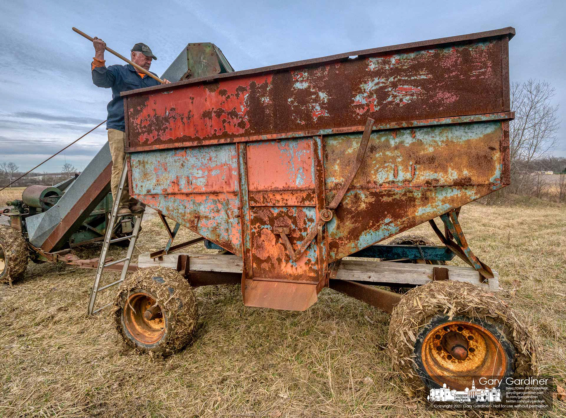 Kevin Scott rakes corn leveling it in the wagon he's using to complete the harvest on the Braun Farm. My Final Photo for March 14, 2021, π Day.