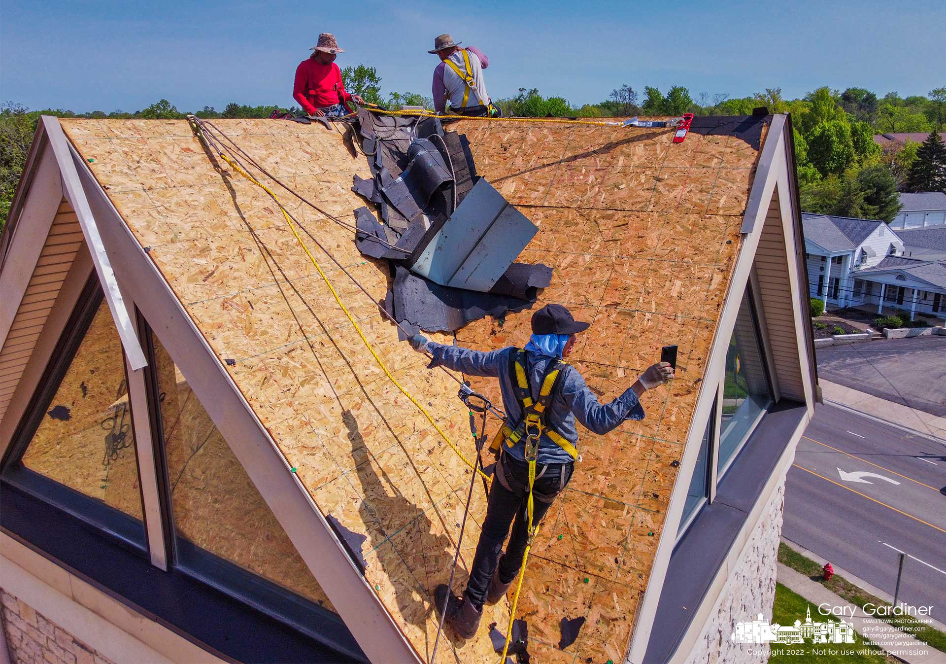 A roofer pauses putting a new roof on Cornerstone Community Church on South State Street to take a selfie with two of his coworkers. My Final Photo for May 12, 2022.