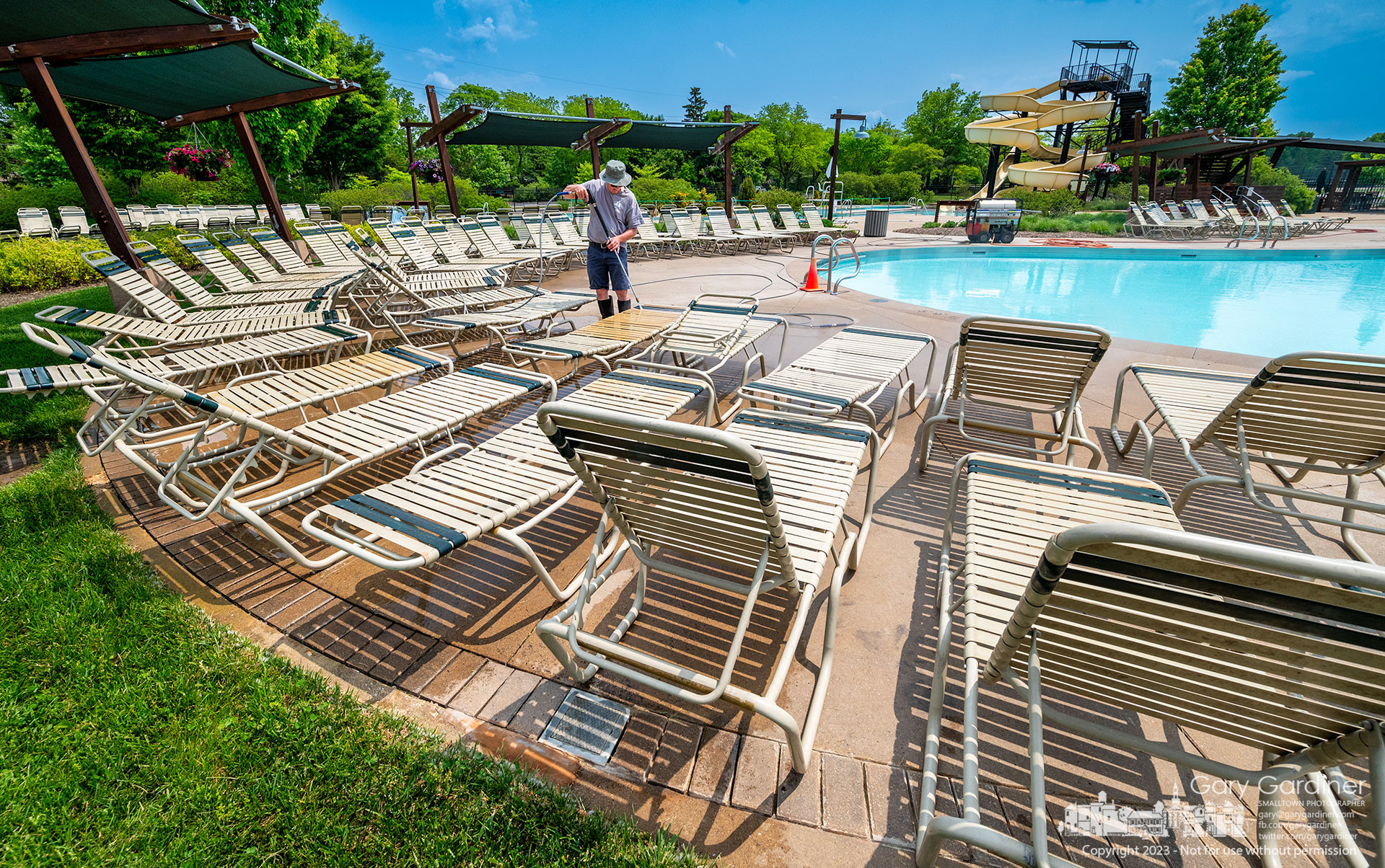 Lounge chairs at Highlands Pool get a final power washing as the aquatic center prepares for opening Saturday. My Final Photo for May 24, 2023. 