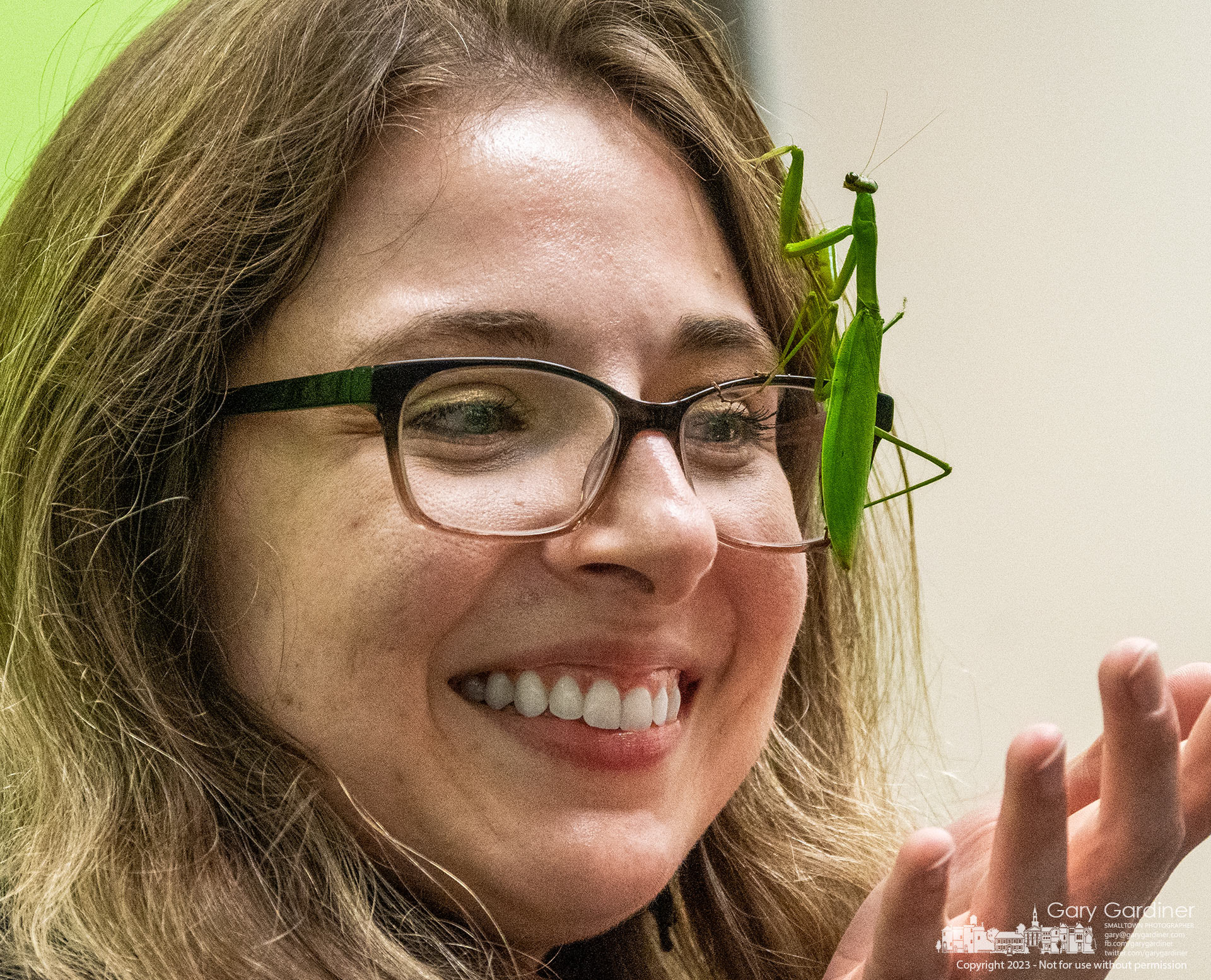 A praying mantis intended to mesmerize children attending BUG OUT insect, arachnid, and centipede show at the Westerville Library climbs the face of a librarian who chose to help manage the insect during a break in the show. My Final Photo for October 14, 2023. https://bit.ly/3Fezdds