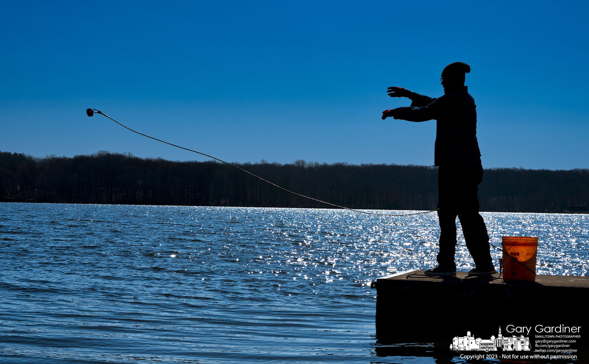 A magnet fisherman tosses his best magnet into Hoover Reservoir from the concrete jetty at the Walnut Street boat ramp only to have it and a second magnet get caught on rocks forcing him to cut the ropes leaving the magnets until the water level is lower for retrieval. My Final Photo for March 20, 2023. 