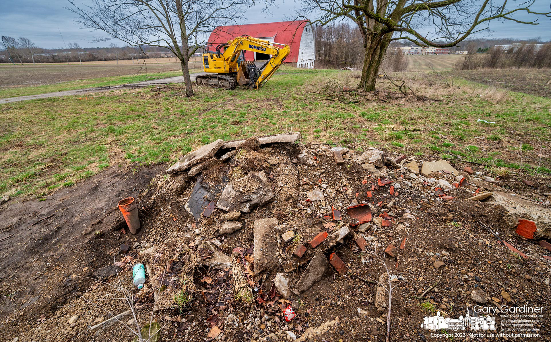 Newly arrived demolition equipment sits about equidistance from the barn and farmhouse at the Braun Farm as work progresses to demolish the two structures. My Final Photo for March 24, 2023. 
