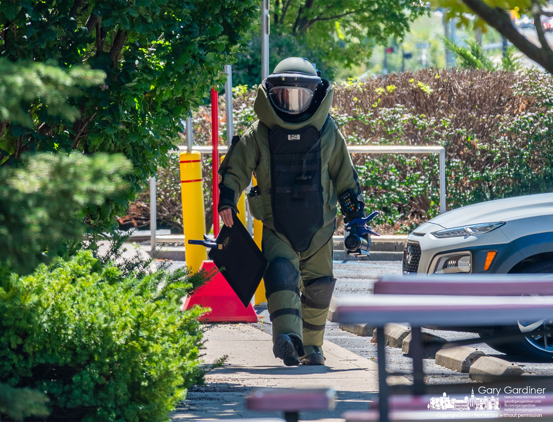 A Columbus police bomb squad officer carries tools he used to test a suspicious package placed on the sidewalk in the parking lot of the CVS pharmacy at Cleveland Ave. and Schrock Road. My Final Photo for September 1, 2023. https://bit.ly/47XAkLC