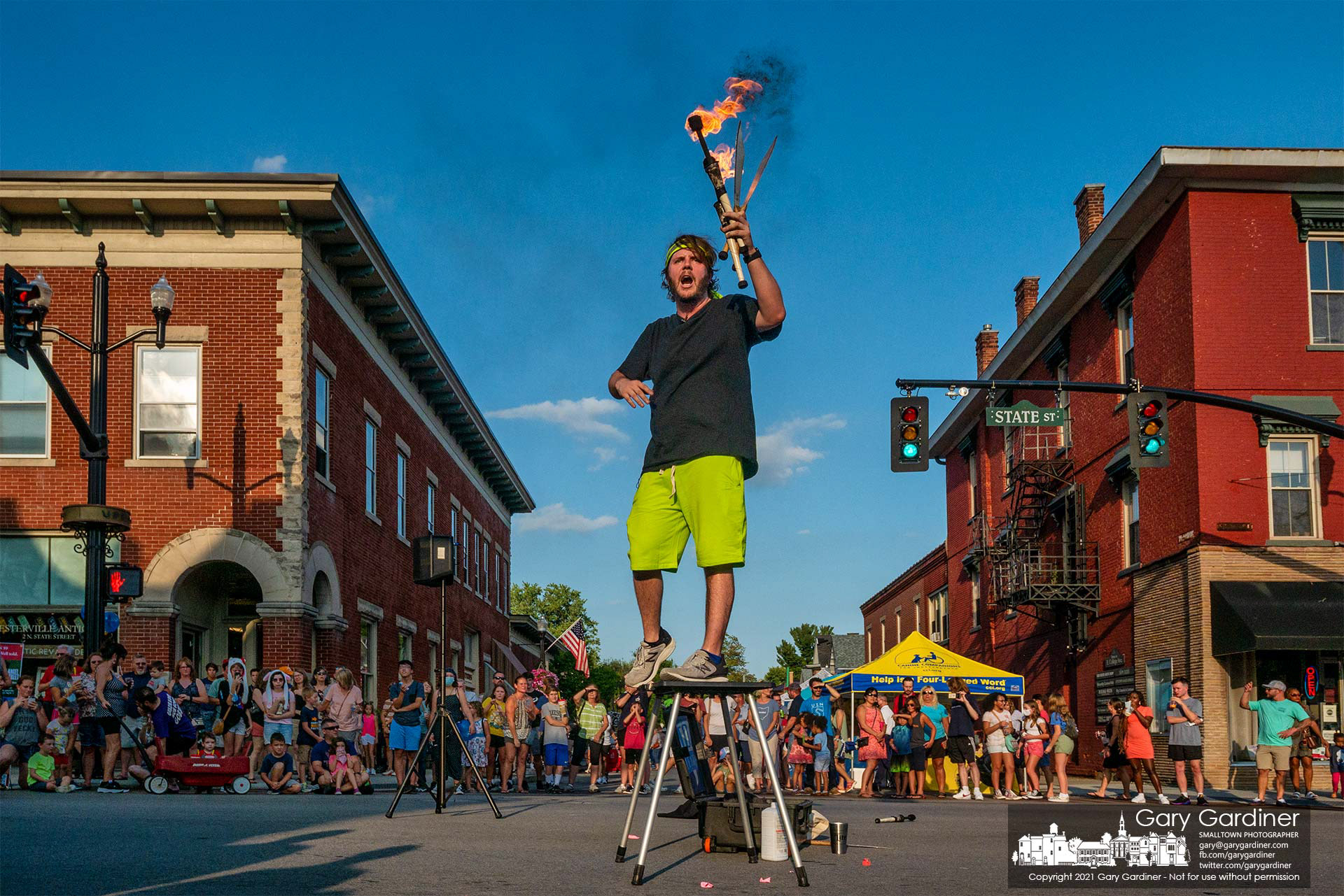 A juggler bearing large knives and flaming batons performs at the center of State and College as part of the Fourth Friday entertainment in Uptown Westerville. My Final Photo for Aug. 27, 2021.