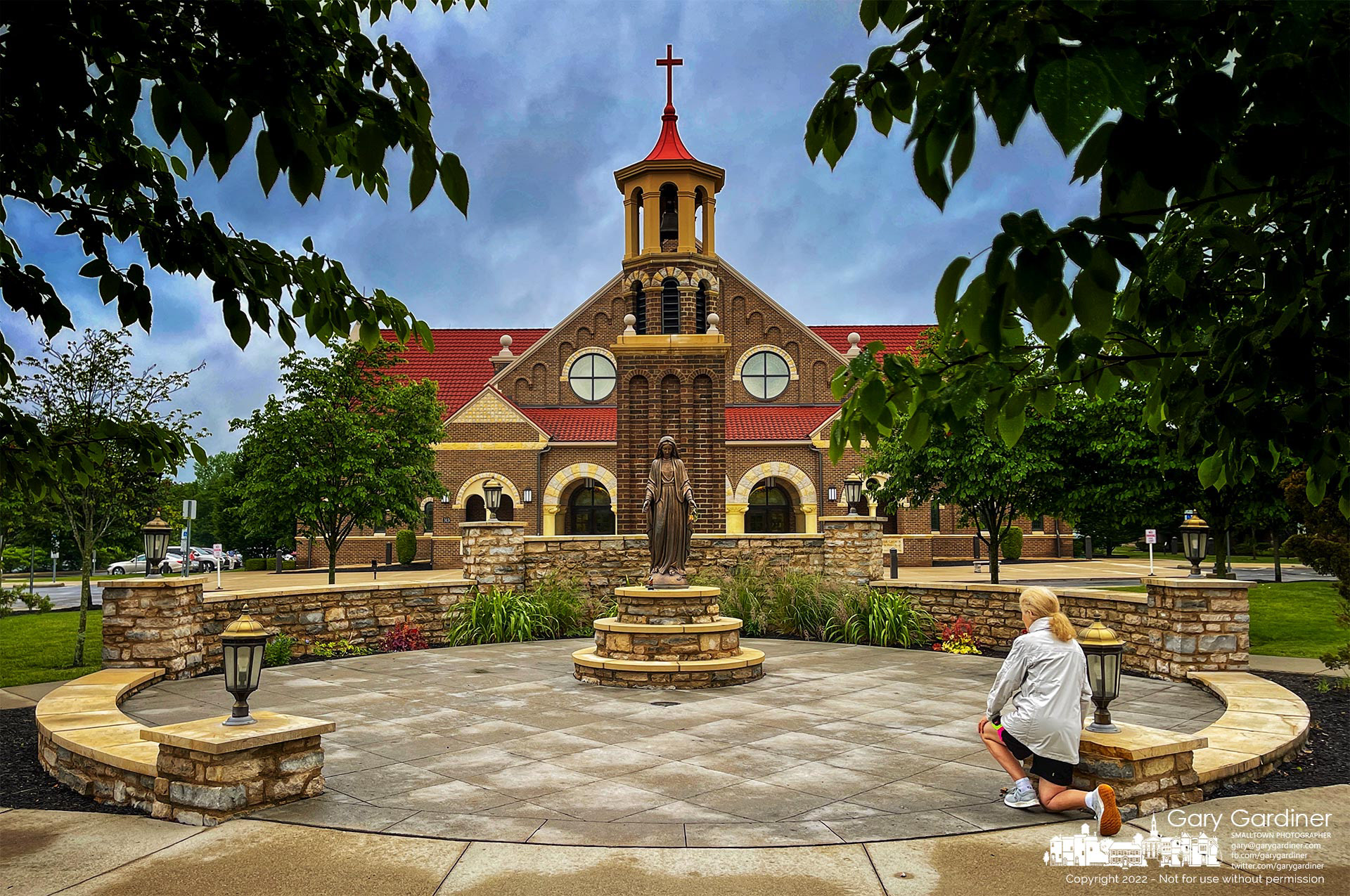 A woman kneels in prayer at the Holy Mary shrine before the first Mass on Sunday. My Final Photo for June 12, 2022.