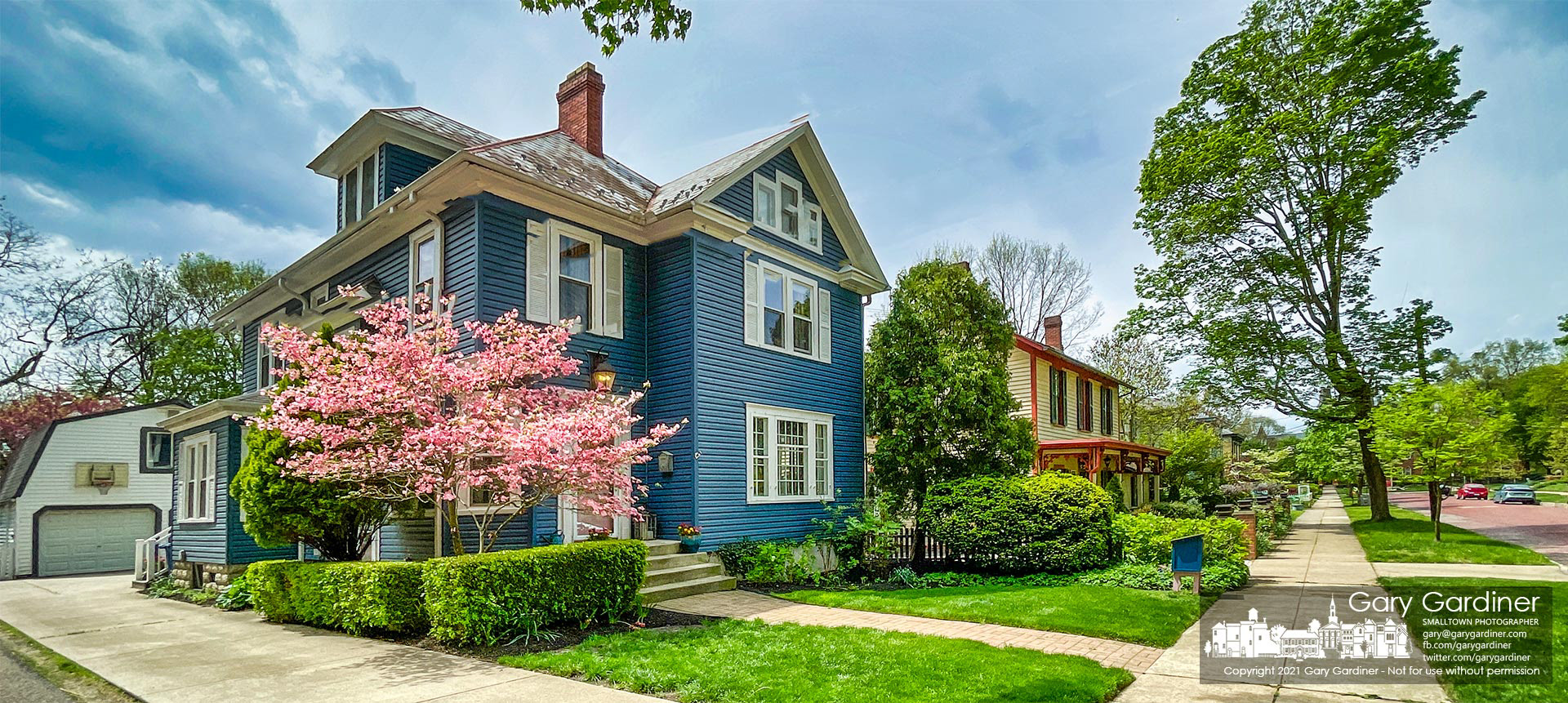 The afternoon sun breaks through heavy clouds brightening a pink dogwood at a West College Ave. home before bringing in colder temperatures and the prospects for a morning frost. My Final Photo for  April 30, 2021.