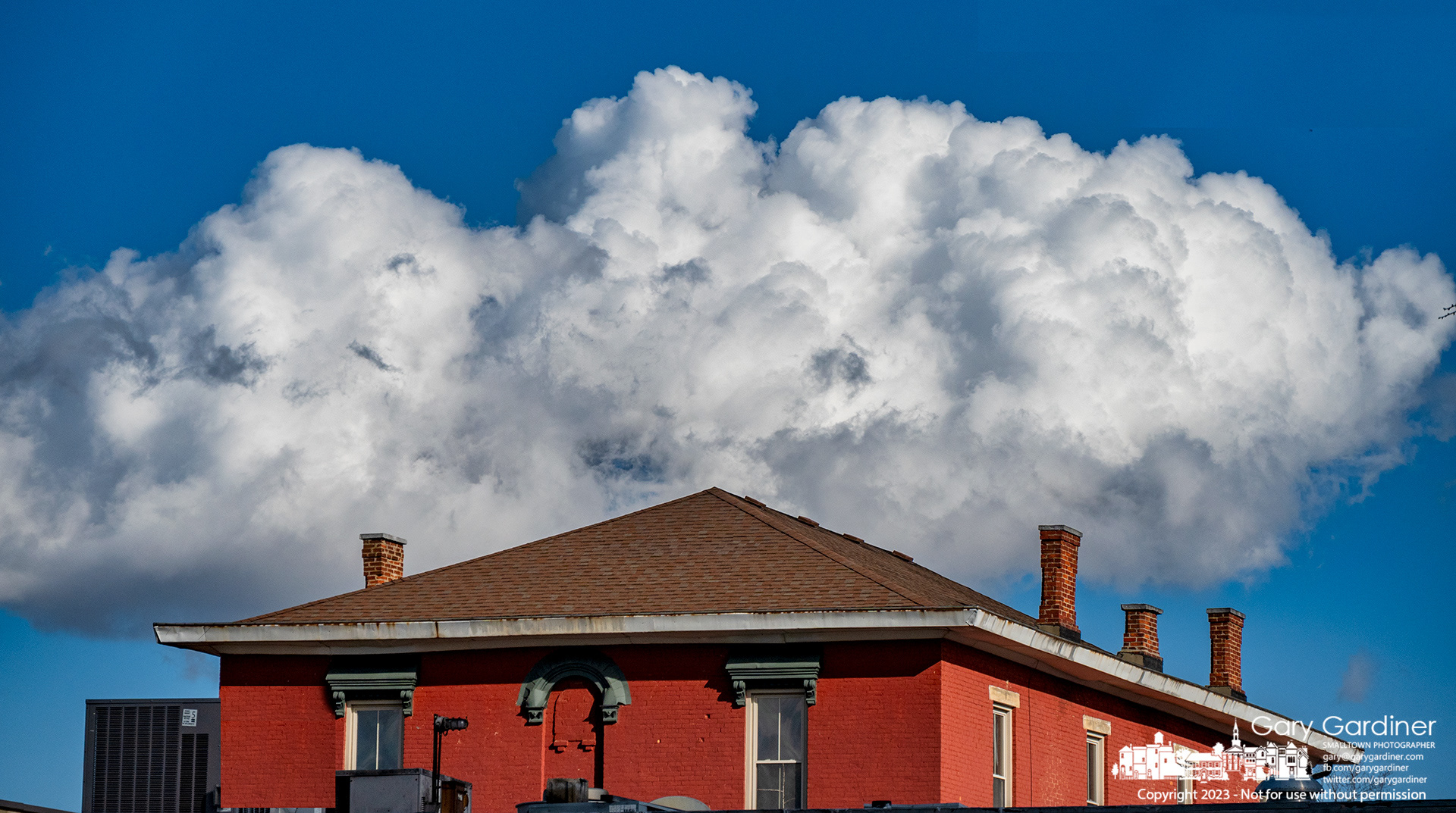 An afternoon cloud moves across the eastern sky appearing to float over buildings in Uptown Westerville but marking the beginning of a strong wind storm and cooler temperatures. My Final Photo for January 19, 2023. 