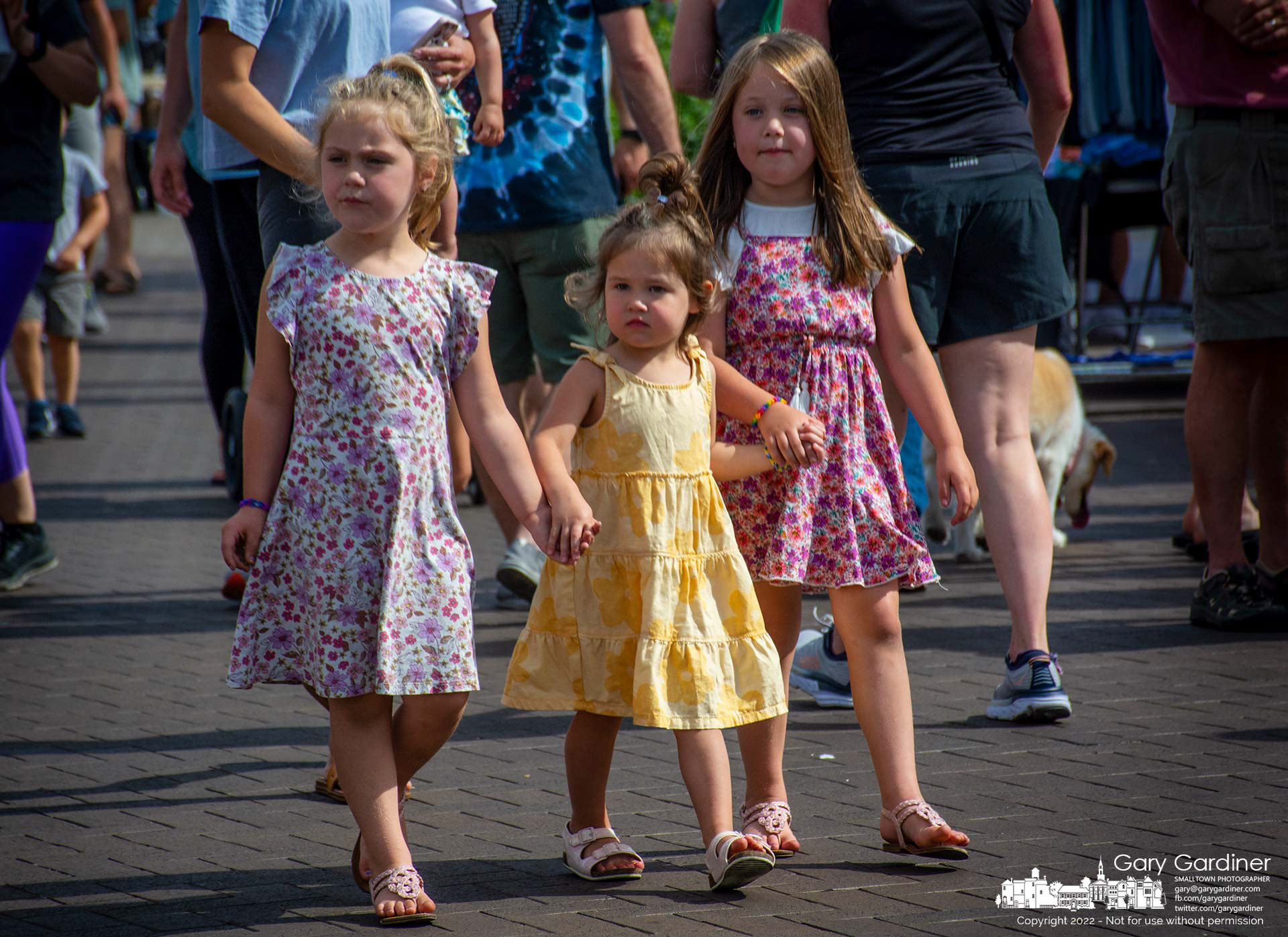 Three girls hold hands and lead their parents through the crowd at the Saturday Farmers Market in Uptown Westerville. My Final Photo for June 25, 2022.