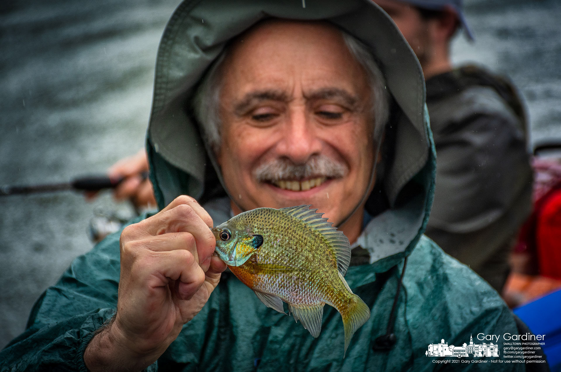 A fisherman admires one of the smaller crappies he pulled in from a lagoon on the western edge of Hoover Reservoir during Tuesday's almost constant rain showers. My Final Photo for Aug. 17, 2021.