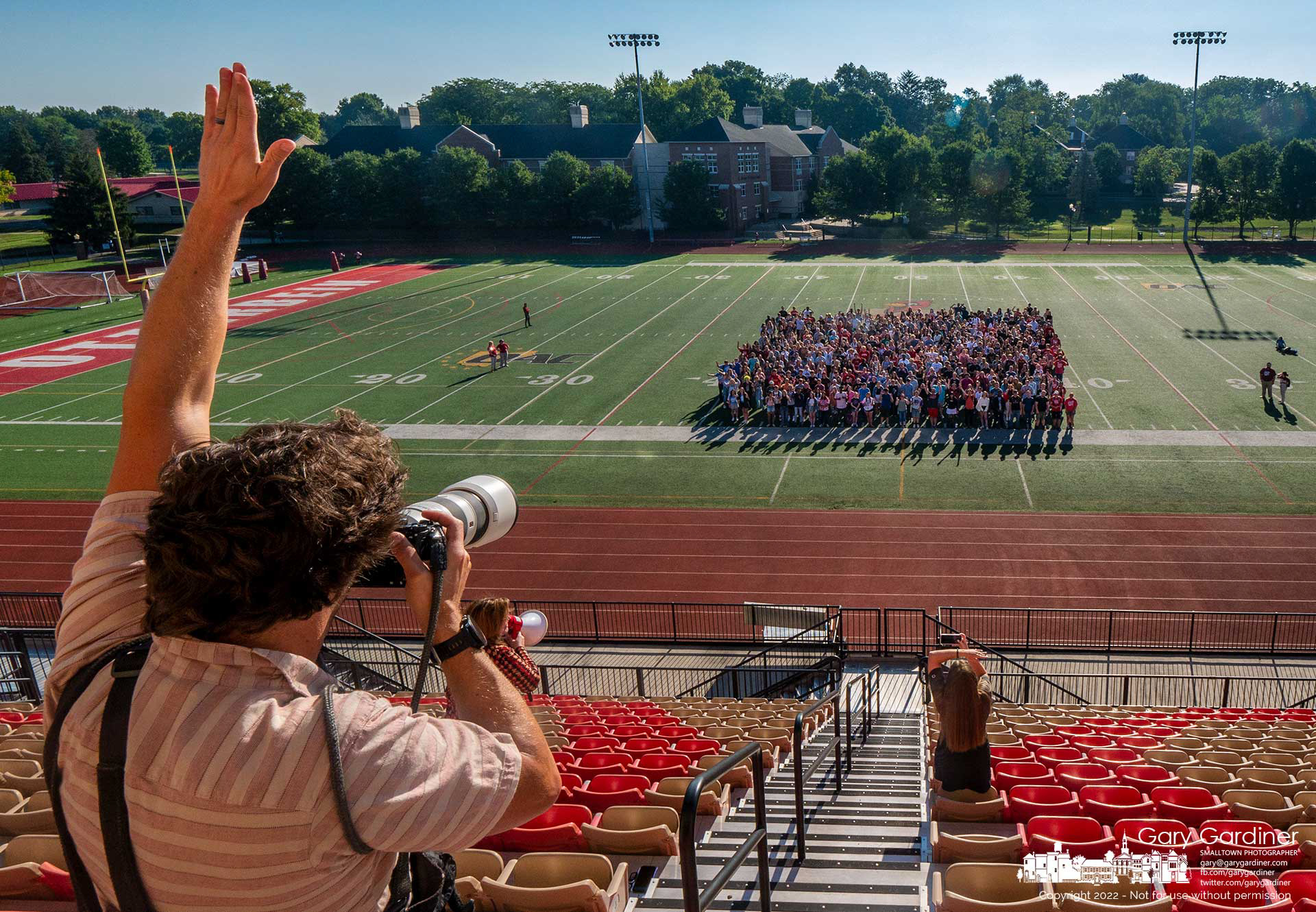 Photographer Jeffry Konzal signals the Otterbein University freshman class posing for the first class photo taken at the university’s football stadium. This week is freshman orientation week with classes starting Monday. My Final Photo for August 18, 2022.