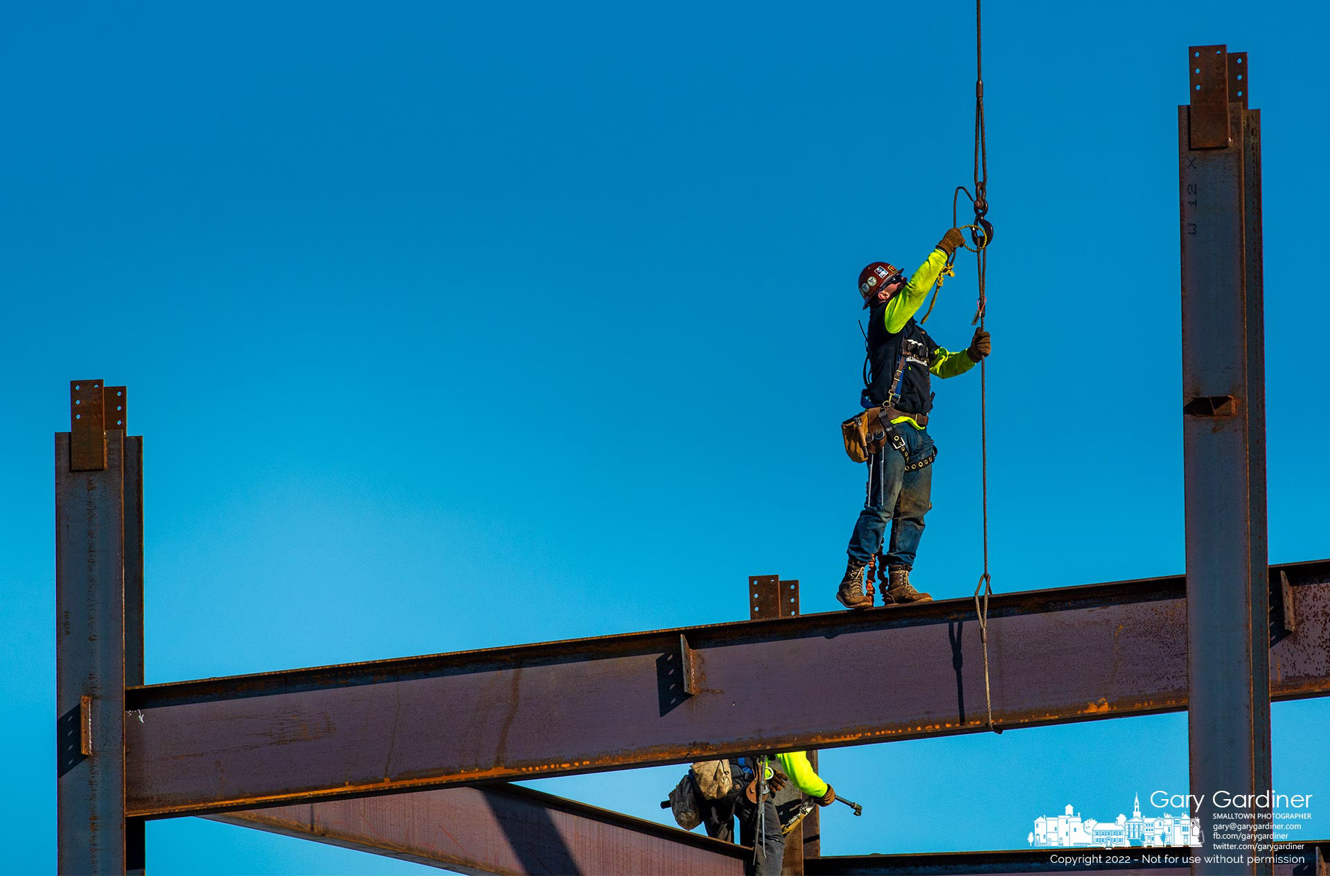 A steelworker attaches his safety gear to the hook connected to a steel beam being lowered into place for the third floor of the new four-story Orthopedic One headquarters building under construction at the corner of Polaris Parkway and Africa Road. My Final Photo for Feb. 9, 2022. 