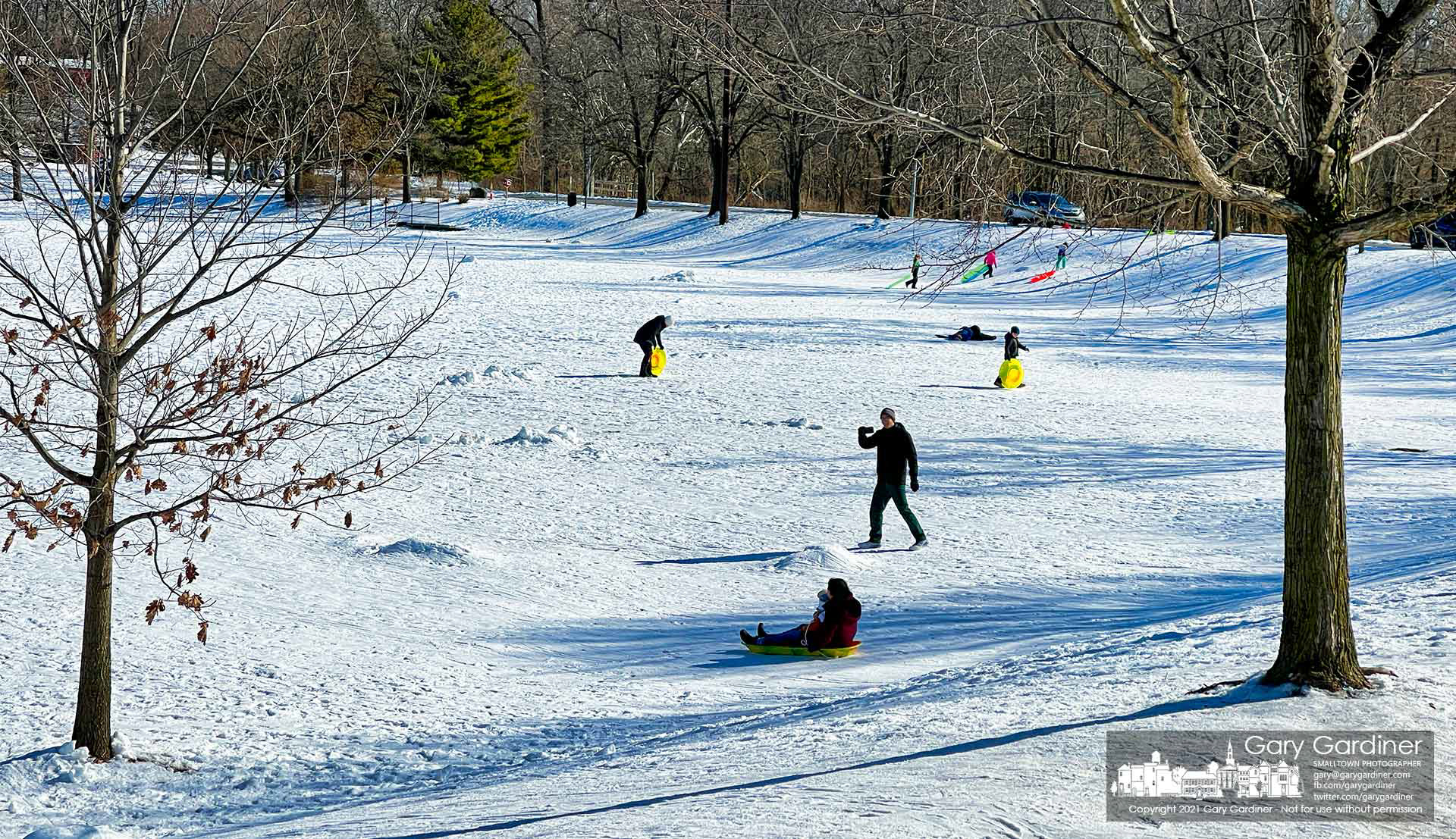 A father runs down the snow-covered incline at Alum Creek Park to make a video of his wife and child riding a sled on the packed snow. My Final Photo for Feb. 6, 2021.