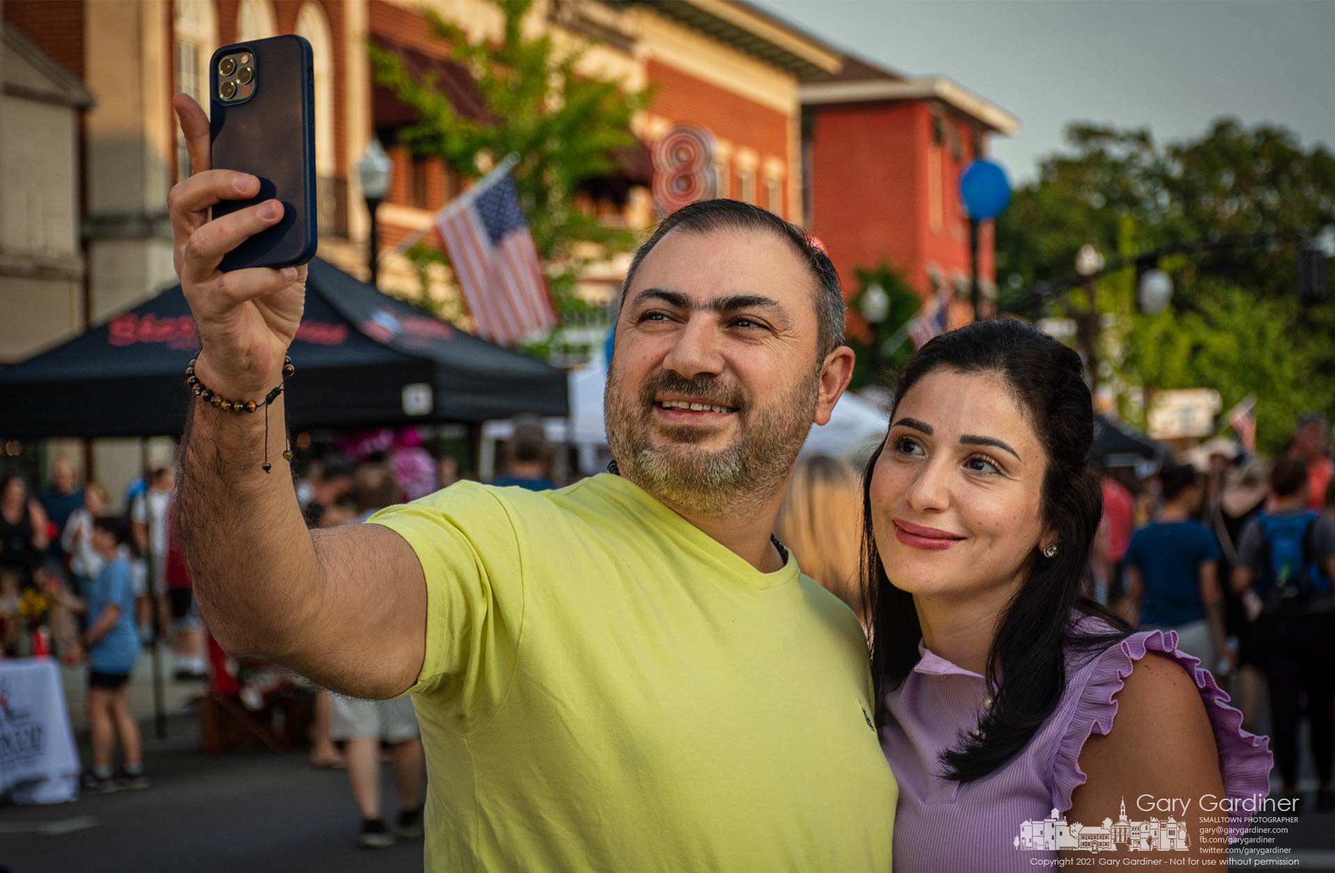 A couple pauses to photograph themselves with their smartphone in the middle of the intersection of State and Main during Fourth Friday in Westerville. My Final Photo for July 23, 2021.