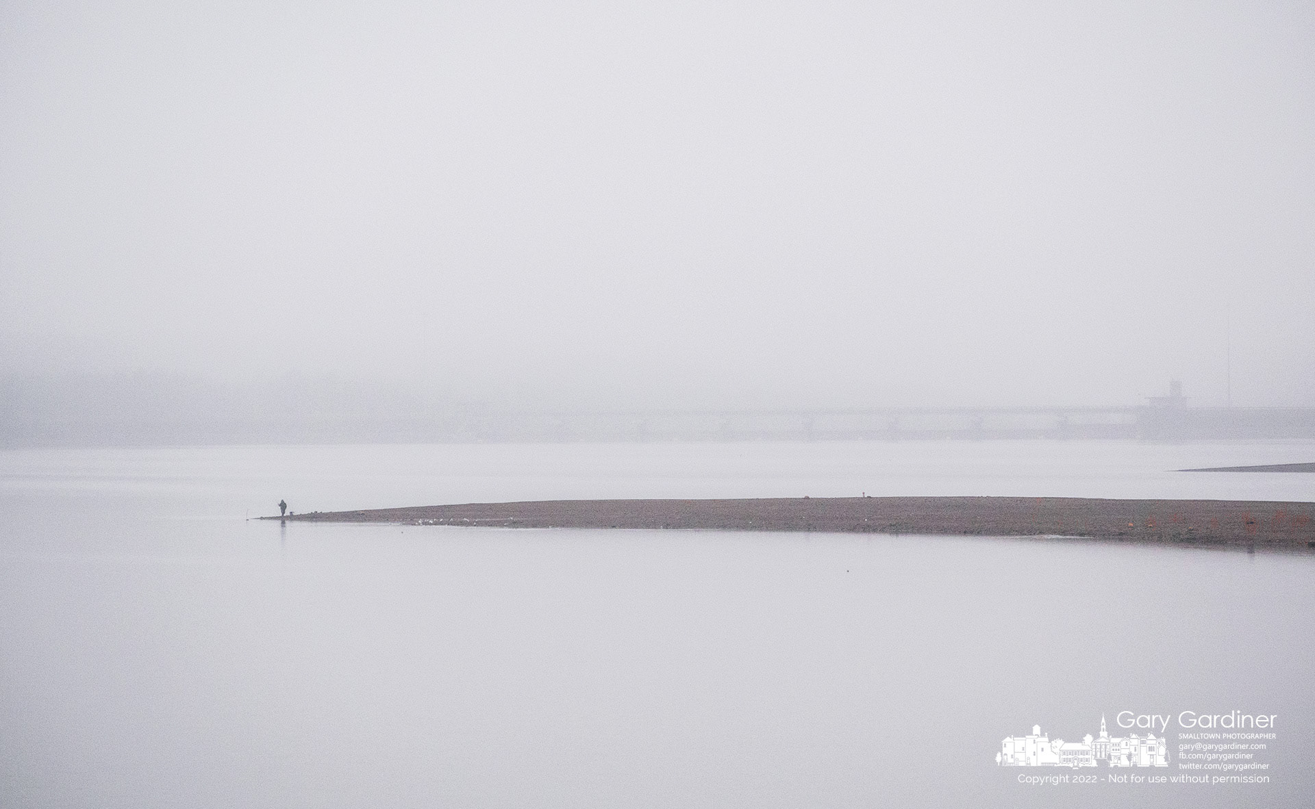 A fisherman stands in afternoon fog and mist at a distance from the dam at Hoover Reservoir hoping for luck after walking to the edge of the lake on a spit of land exposed by low water. My Final Photo For December 6, 2022.