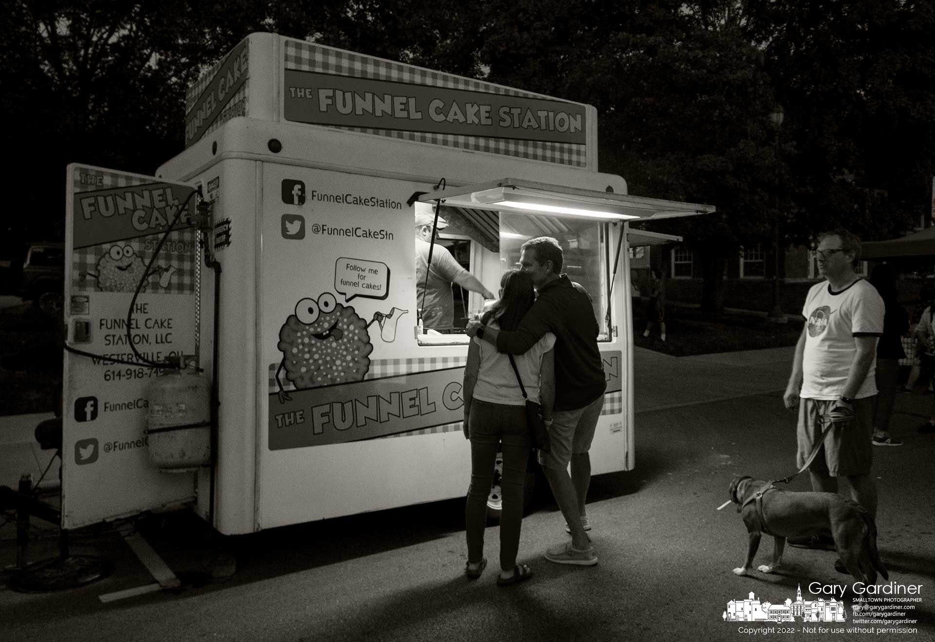A couple stands ready for their funnel cake as another customer waits in line for the fried dough specialty sold at Fourth Friday in Uptown Westerville. My Final Photo for August 26, 2022.