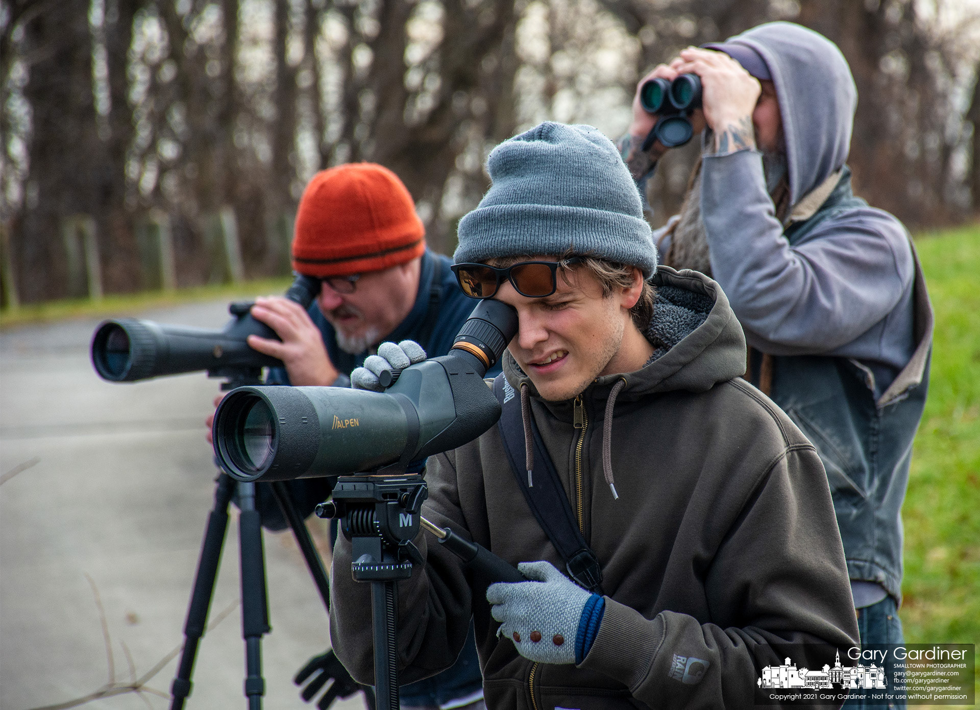Three birders study a flock of seagulls trying to separate a little gull from other gulls hoping to add the rare bird to their bird life list. My Final Photo for Dec. 9, 2021.