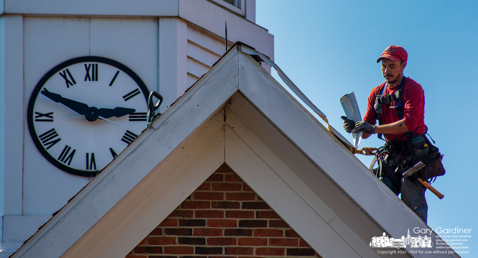 A roofer removes the old flashing on the dormer over the city hall main entrance as work began Tuesday replacing the roof and much of its sheathing. My Final Photo for September 20, 2022.