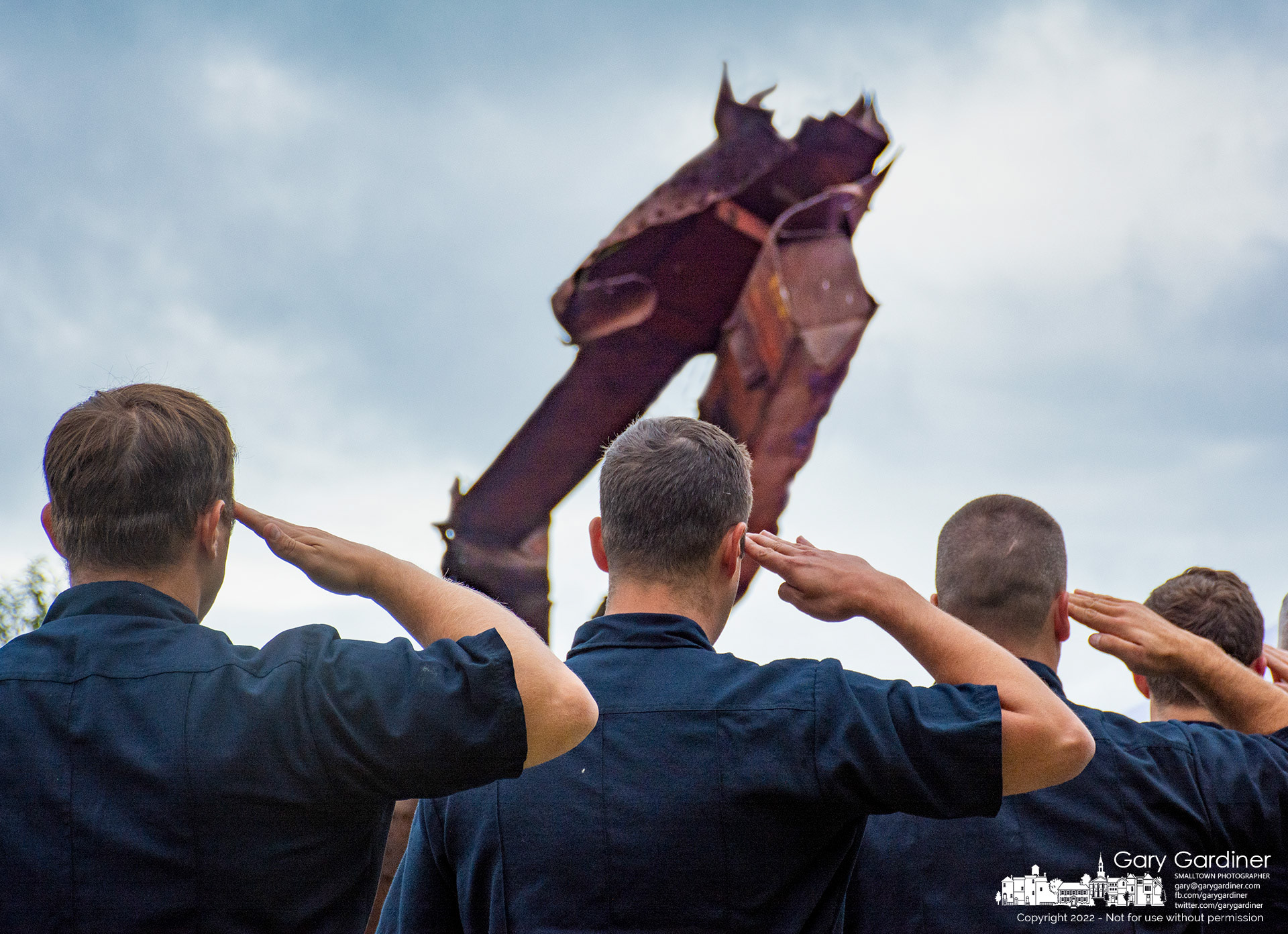 Westerville firefighters salute during the opening moments for Sunday's 9/11 memorial service at First Responders Park in Westerville with a section of steel from the World Trade Center at the center of their view. My Final Photo for Sept. 11, 2022.