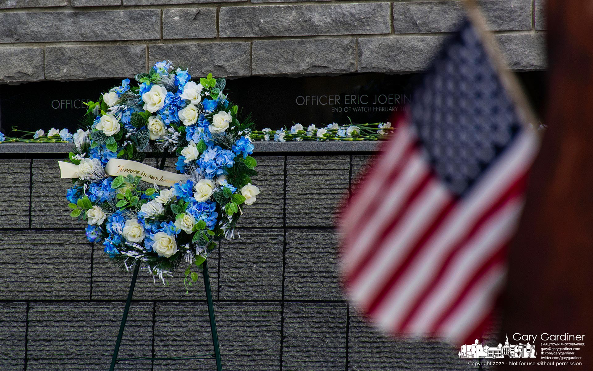 An American flag hangs from the World Trade Center steel at First Responders Park where a memorial wreath marking the 4th anniversary of the on-duty deaths of Westerville police officers Anthony Morelli and Eric Joering stands in front of their names on the wall at the park on West Main. My Final Photo for Feb. 10, 2022. 