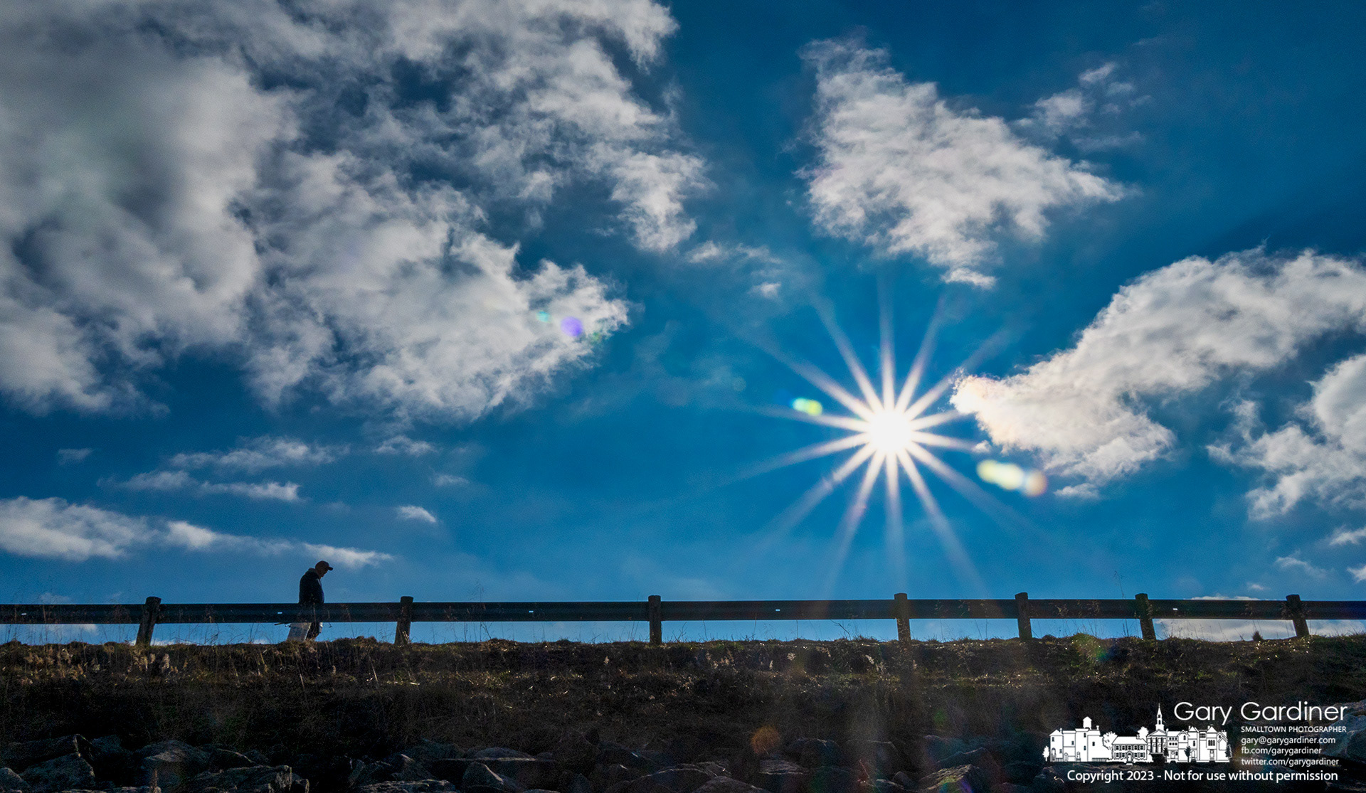 A man crosses Hoover Dam beneath an almost clear winter sky with the sun shining bright warming him on his walk. My Final Photo for January 7, 2023.