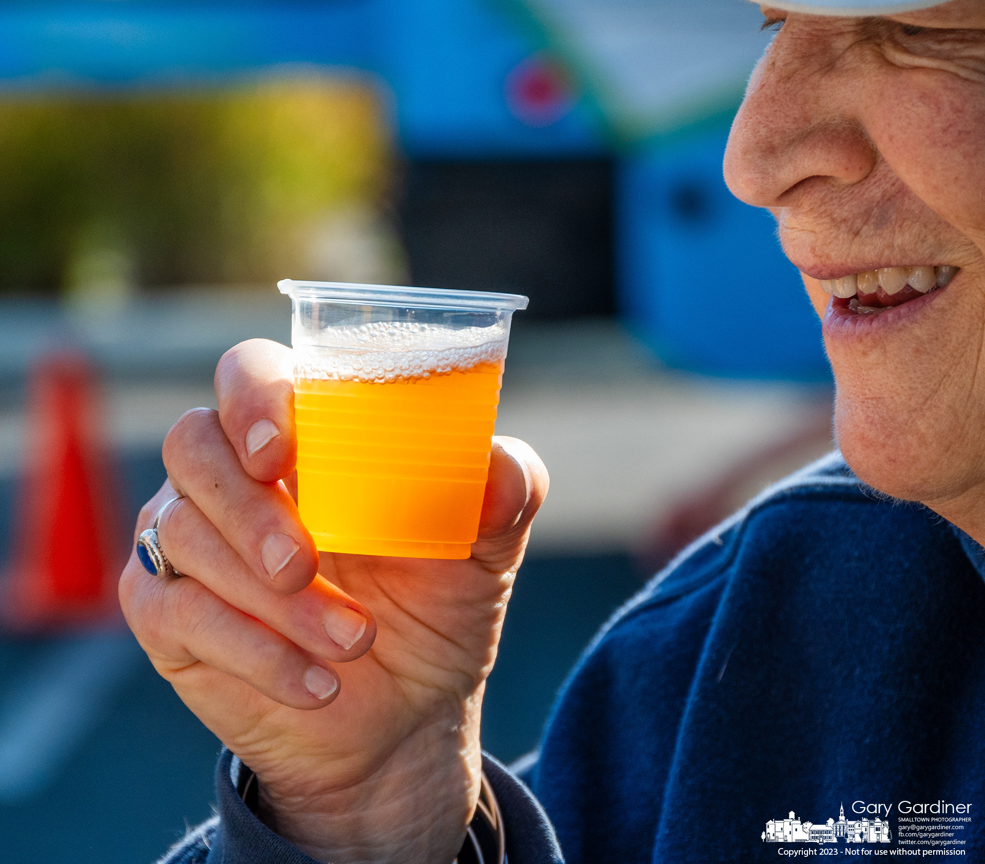 A man smiles after toasting a friend with a sample cup of apple cider from an Amish farm at the last Saturday Farmers Market of the season in Westerville. My Final Photo for September 30, 2023. https://bit.ly/46yKD7d