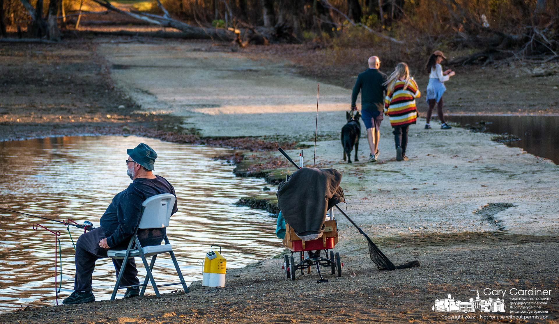 A fisherman watches his lines thrown into Hoover Reservoir as people walk across an exposed section of the old Sunbury Road that is usually covered by water from the reservoir. My Final Photo for October 29, 2022.