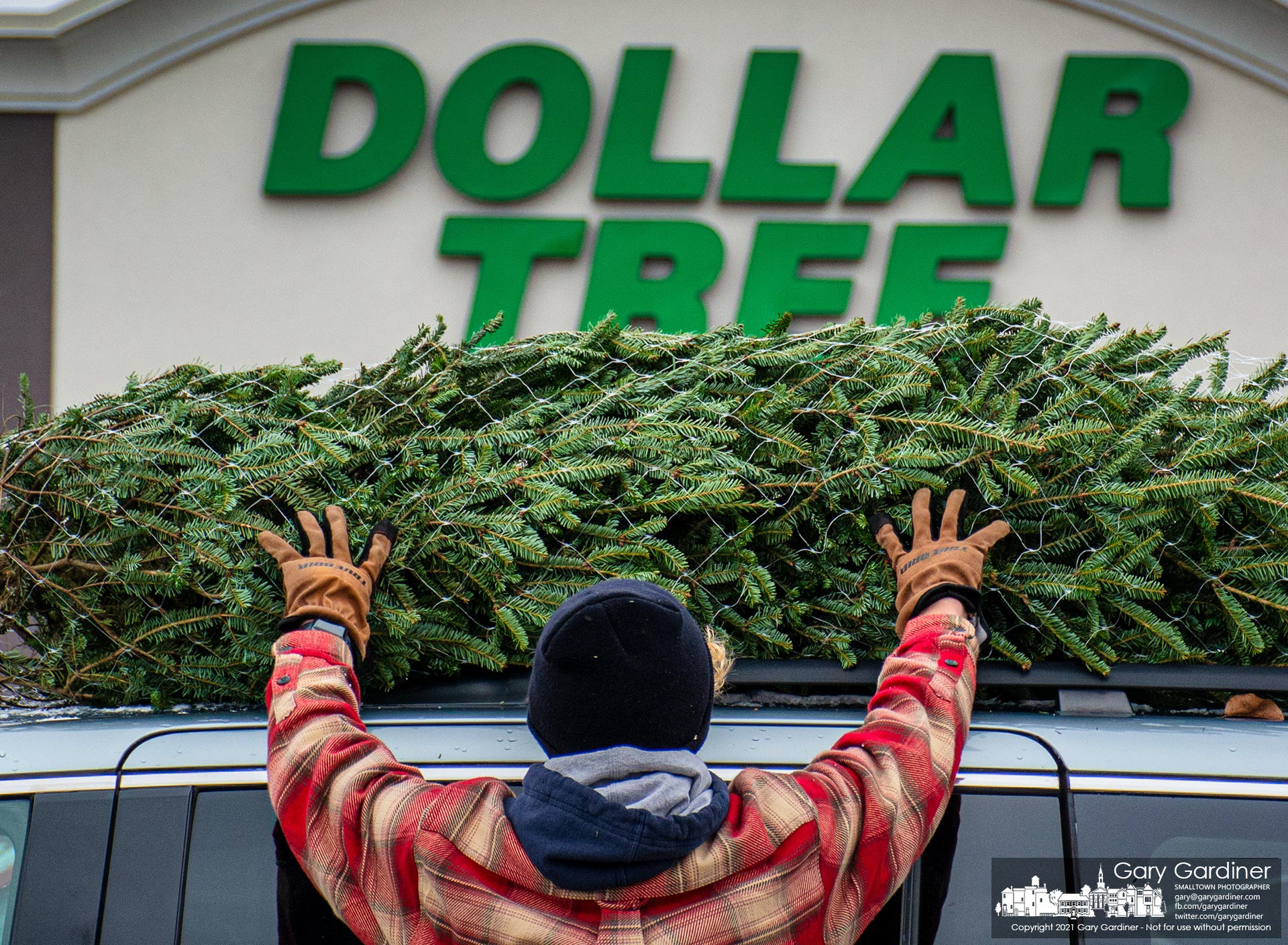 A Christmas tree is placed on top of a van for its trip to a new home on the first day of tree sales at the lot at the front of Glengary Shopping Center. My Final Photo for Nov. 26, 2021.