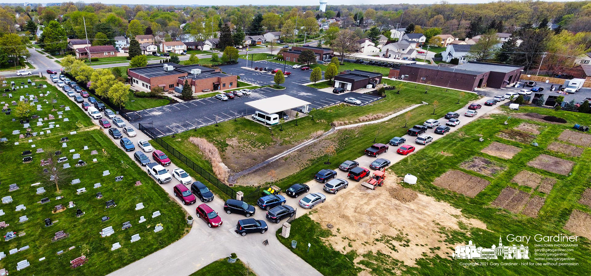 A double line of cars extends into South Hempstead Rd. from the garage area at Blendon Township offices as people arrived mainly to drop off papers for free shredding and to leave unused drugs for disposal. My Final Photo for April 24, 2021.