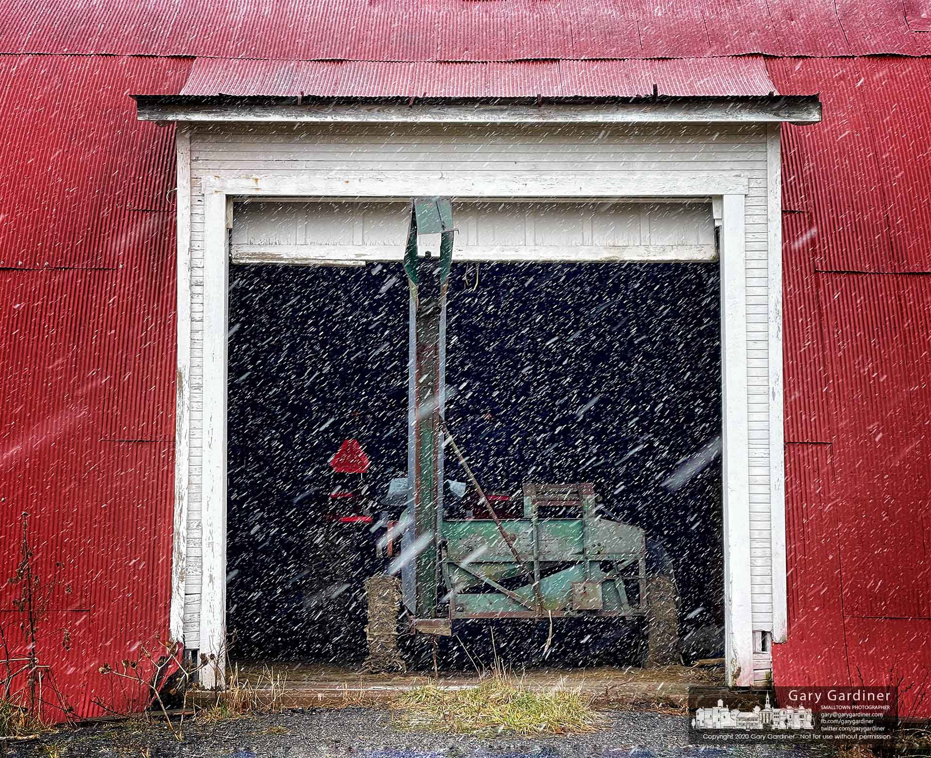 A heavy snow squall blows across the open door of the barn at the Braun Farm where a corn picker waits for repairs. My Final Photo for Jan. 17, 2021.