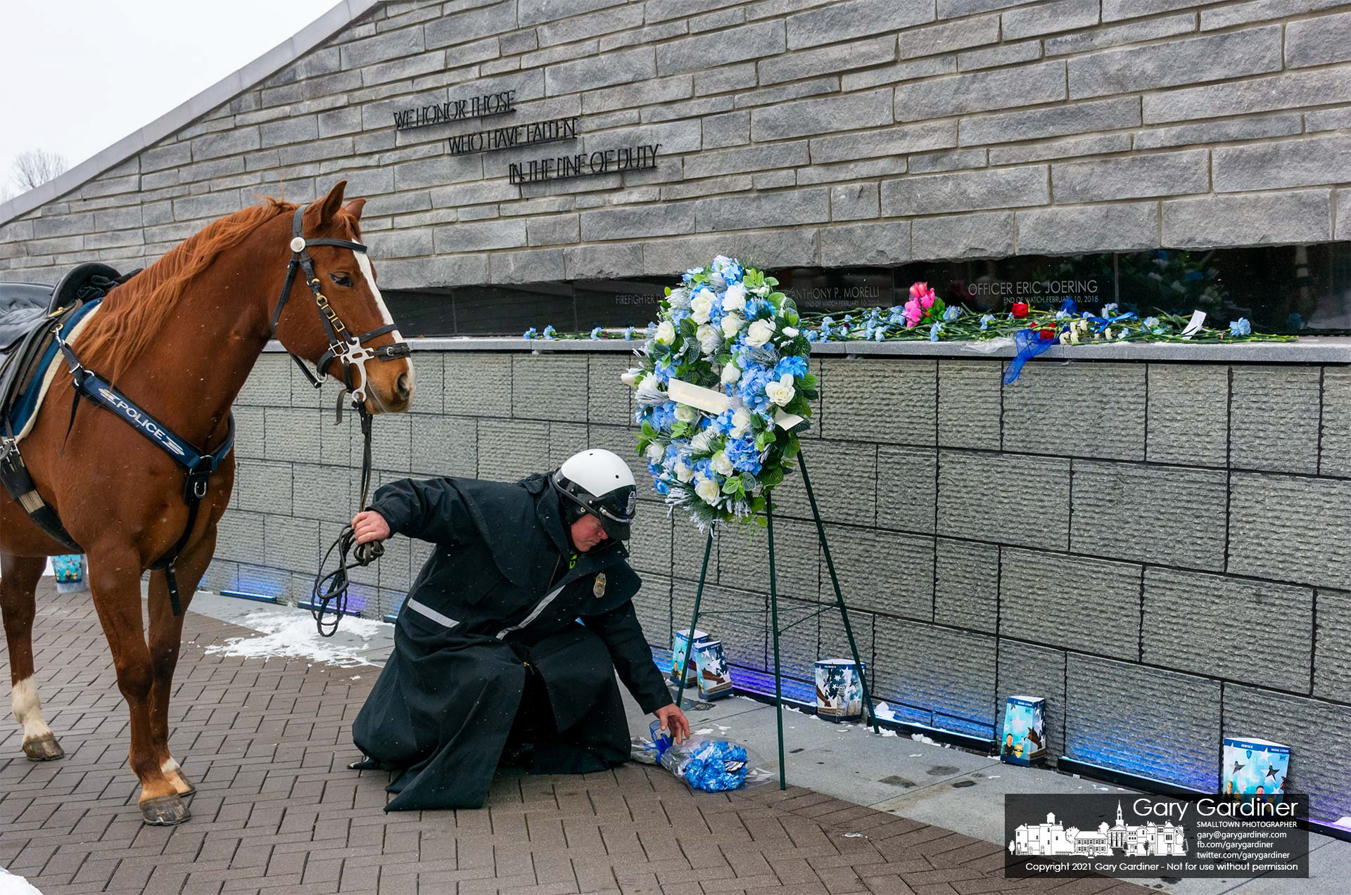A Columbus Police Mounted Patrol officer lays flowers at First Responders Park in Westerville on the anniversary of the deaths of two officers killed while answering a domestic violence call. My Final Photo for Feb. 10, 2021.