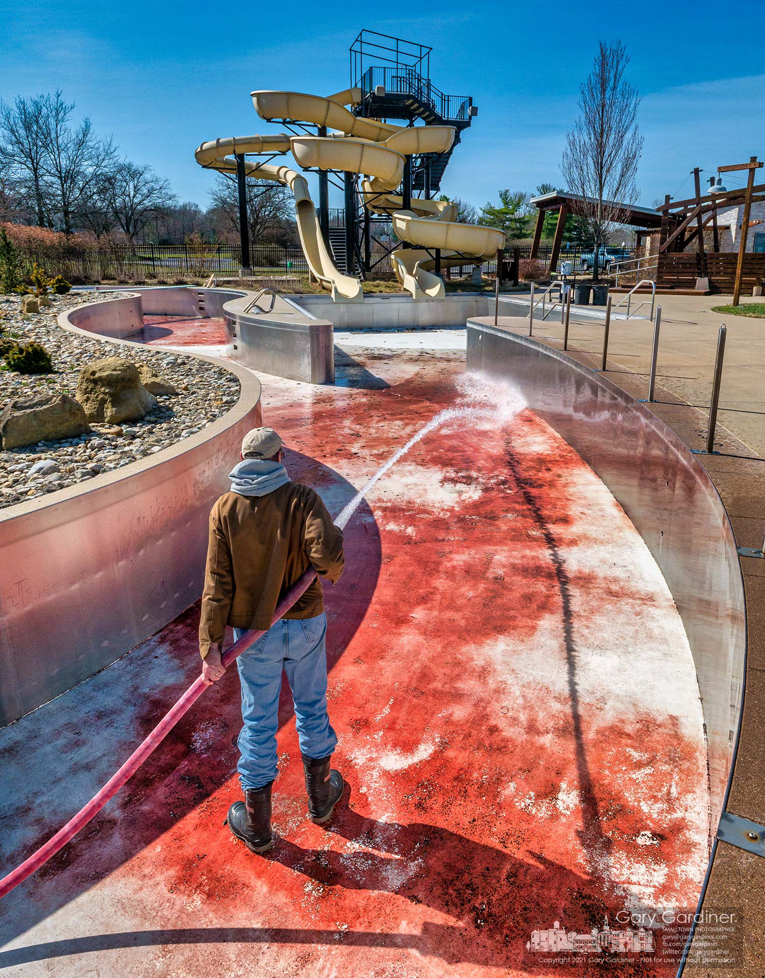A Westerville Parks and Recreation worker sprays debris and dirt from the lazy river pool at Highlands Aquatic Center in preparation for possible opening this year after the pool stayed closed last year because of the pandemic. My Final Photo for March 22, 2021. P