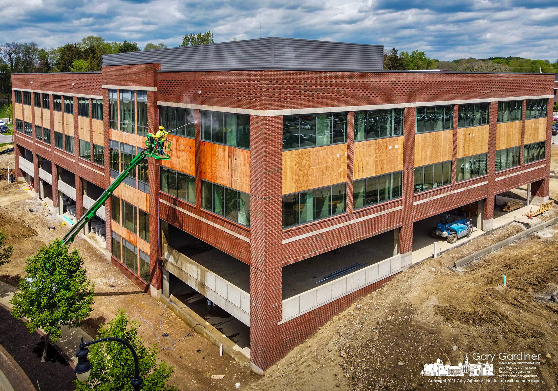 A work crew completes pressure washing the newly laid brick exterior of the third COPC building being built on Africa Road. My Final Photo for May 6, 2021.