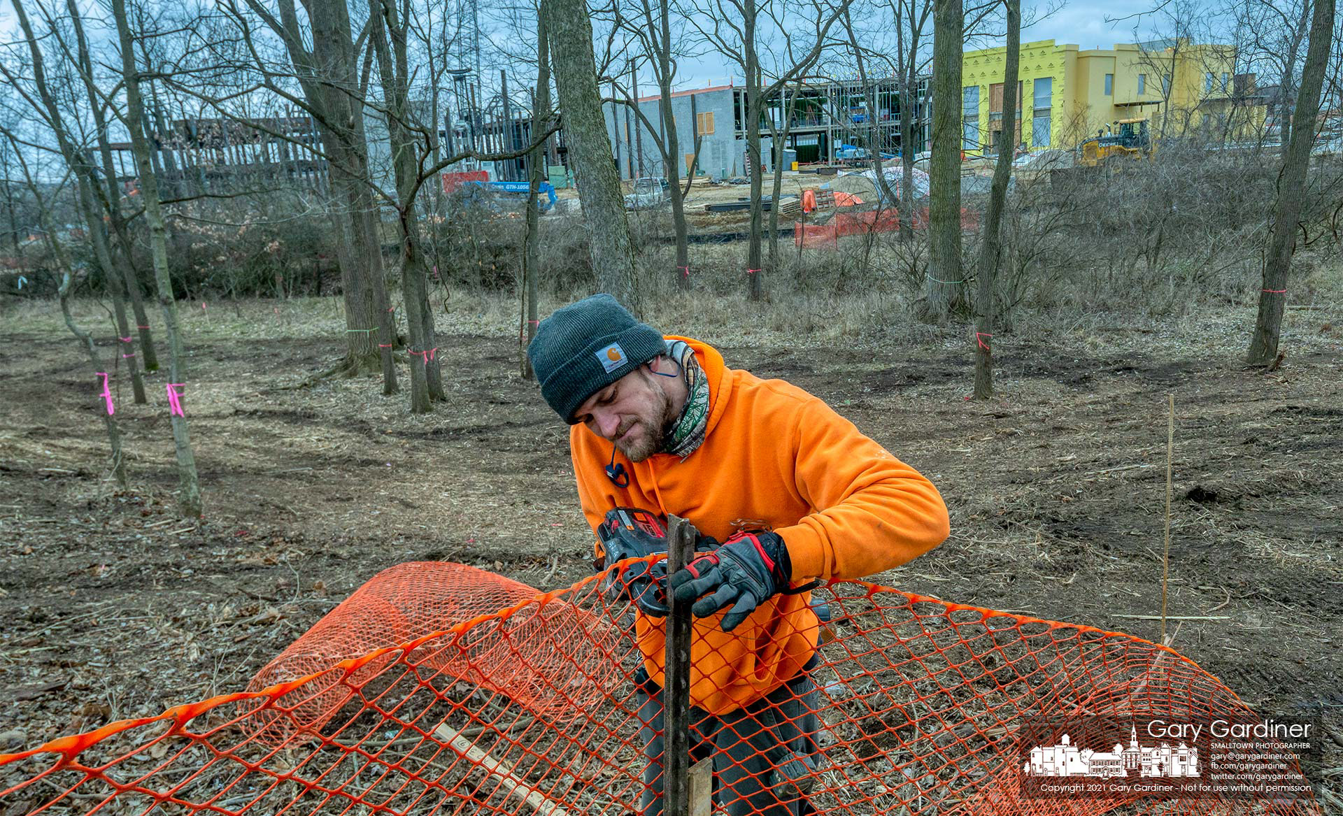 A worker builds a temporary safety fence around a section of the woods cleared at County Line and Africa Roads where a new skilled-nursing health care building is under construction. My Final Photo for March 4, 2021.