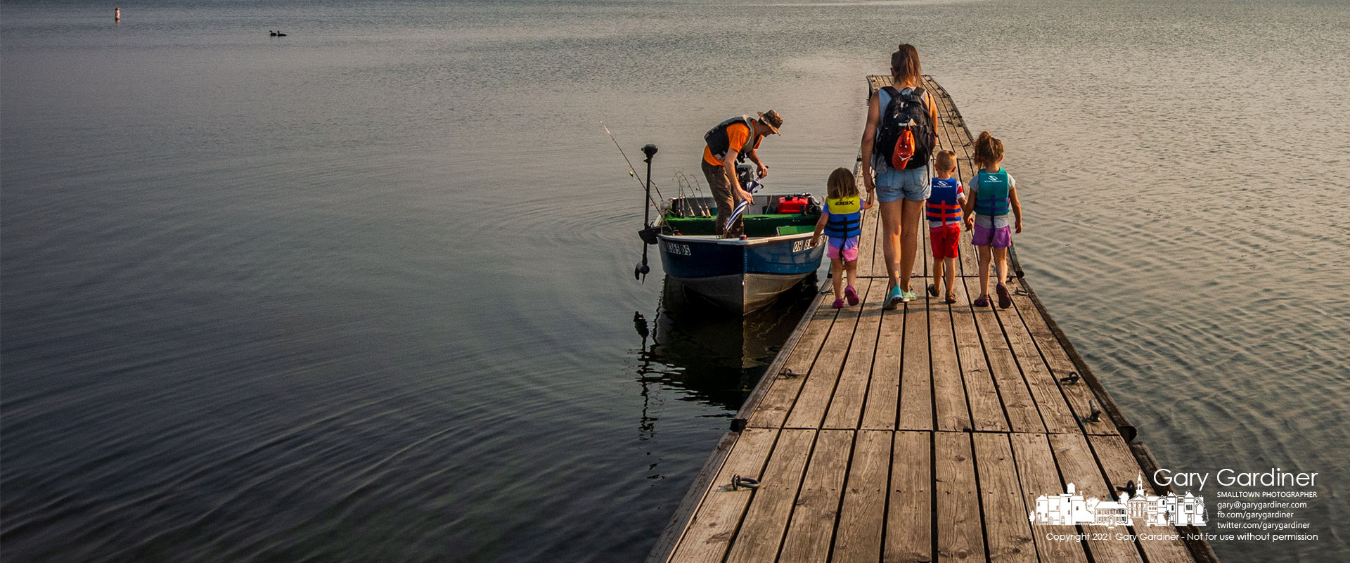 Dad readies the boat as Mom, wearing a backpack filled with snacks, escorts their three children along the Walnut Street boat ramp dock for a day of fishing on Hoover Reservoir. My Final Photo for Sept.13, 2021.