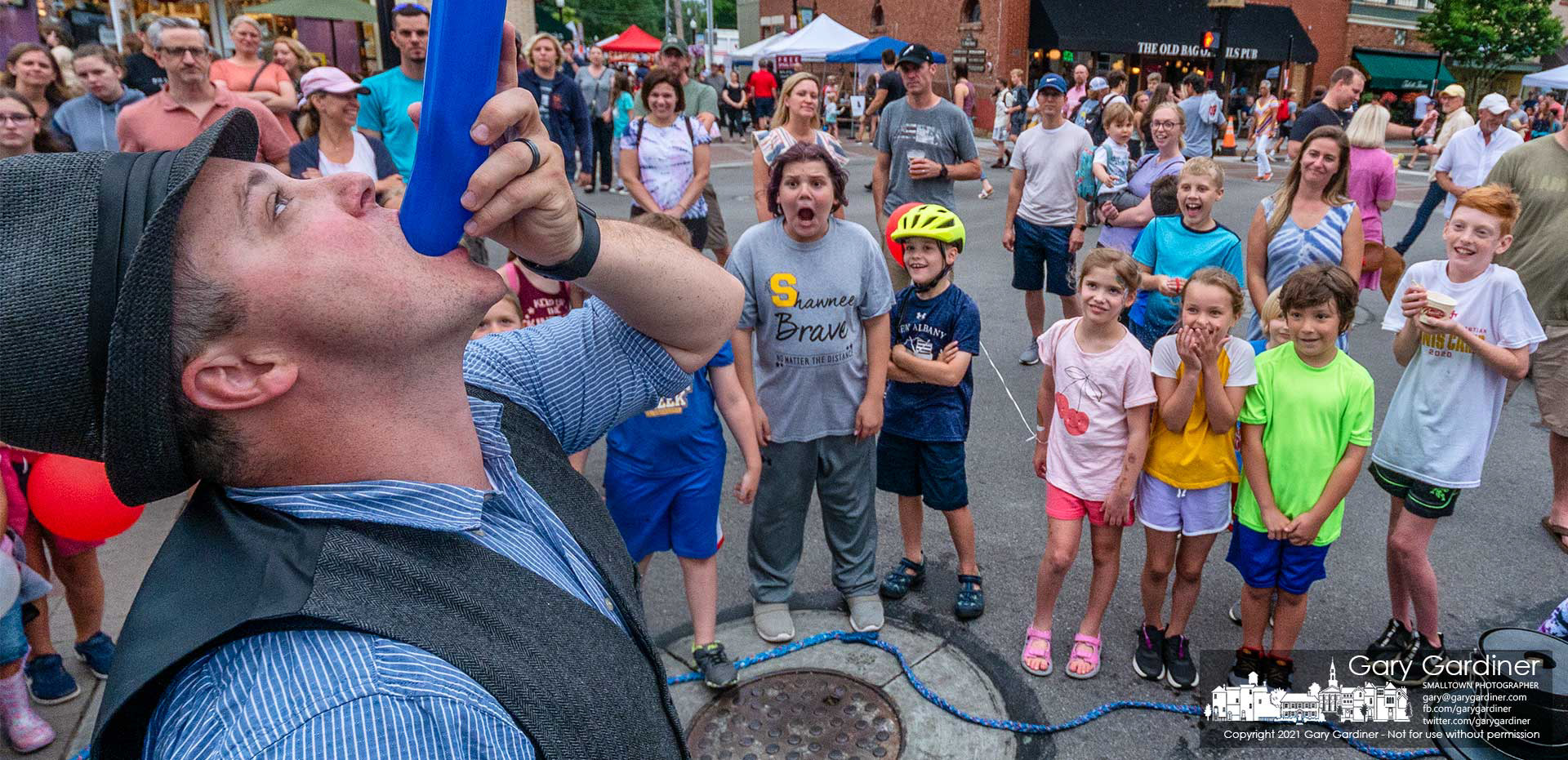 A group of children watches in awe as Magic Nate mysteriously devours a balloon during one of his shows at the first Fourth Friday in Uptown Westerville for 2021. My Final Photo for June 25.