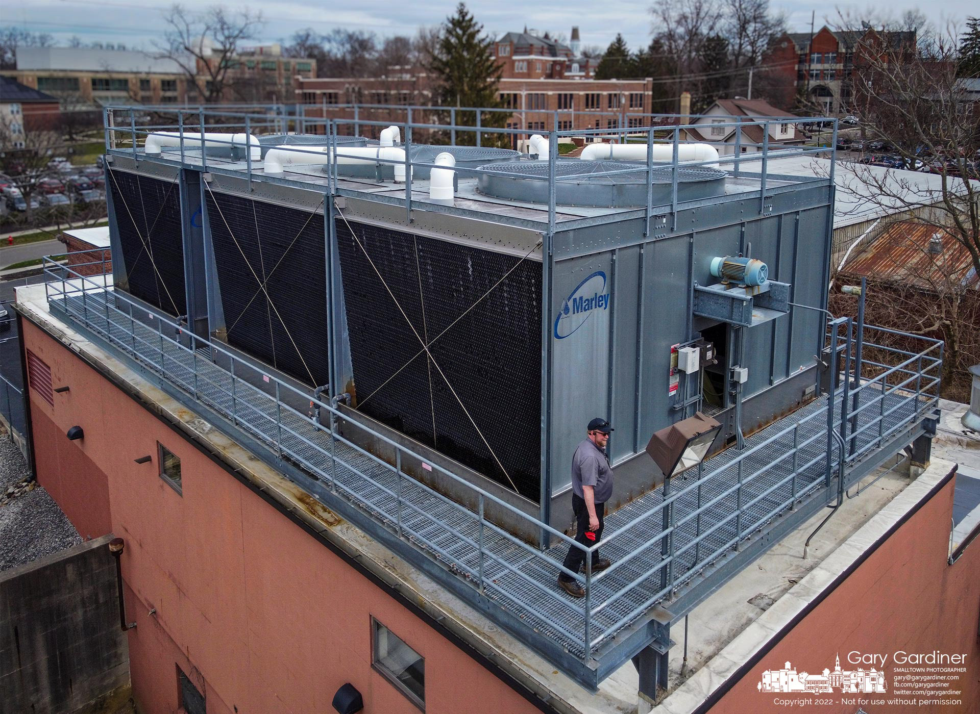 Facility workers at Otterbein University clean and inspect the water cooling tower at the top of the school's service building on West Park in preparation for warmer weather. My Final Photo for March 18, 2022.