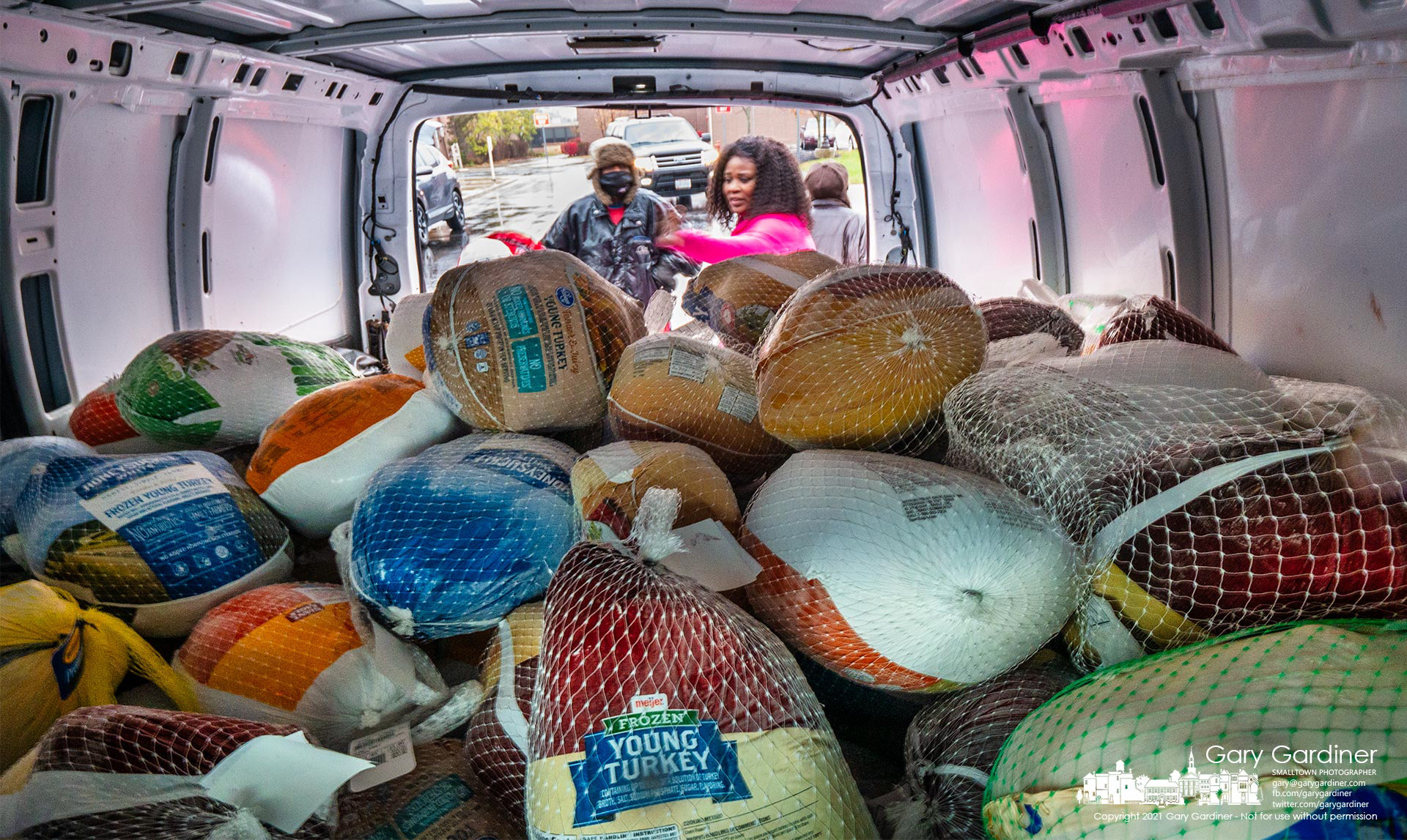 Volunteers toss frozen turkeys into a utility van as St. Paul The Apostle church collects turkeys for its sister parish in Columbus, Holy Rosary-St. John. My Final Photo for Nov. 21, 2021. 