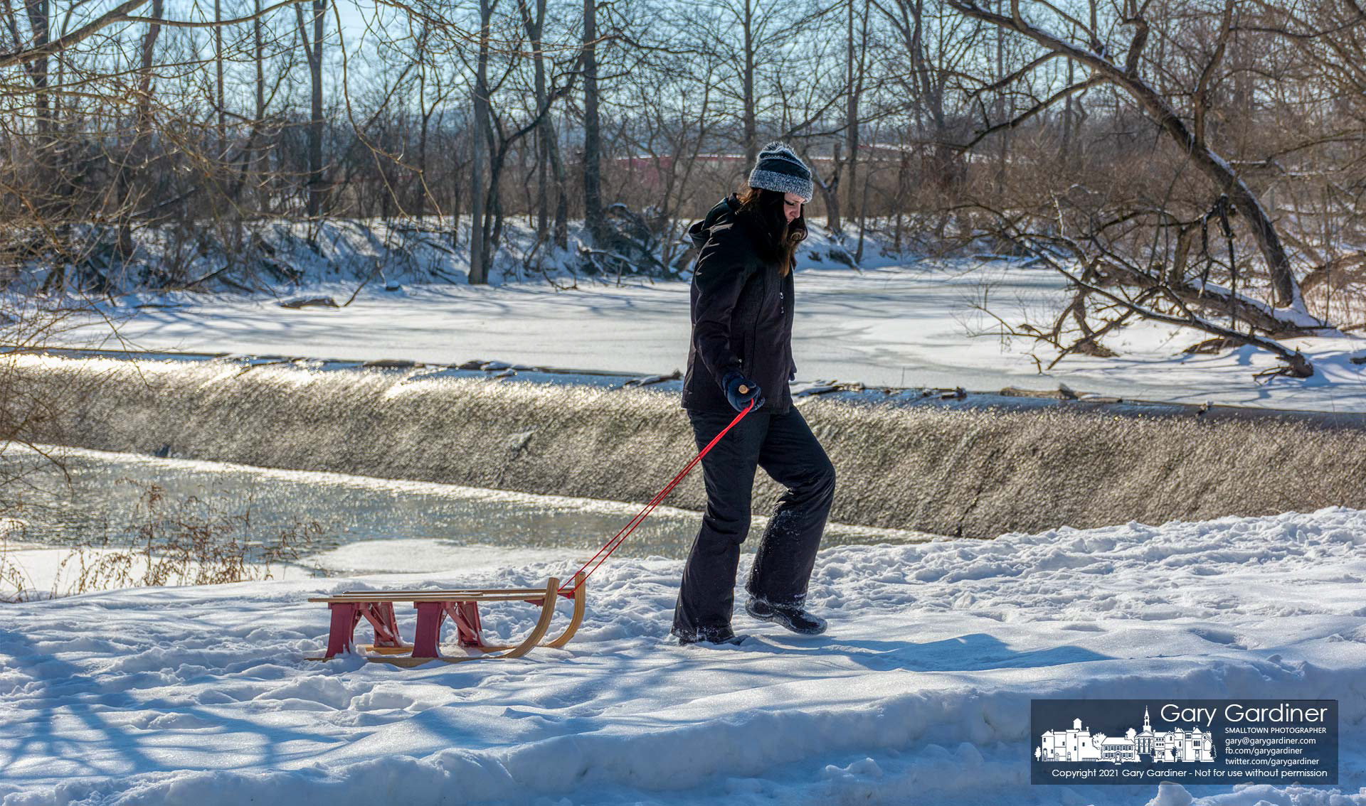 A young woman drags her sled after she and a friend explored the snow-covered island just below the low-head dam at Alum Creek North. My Final Photo for Feb. 20, 2021.