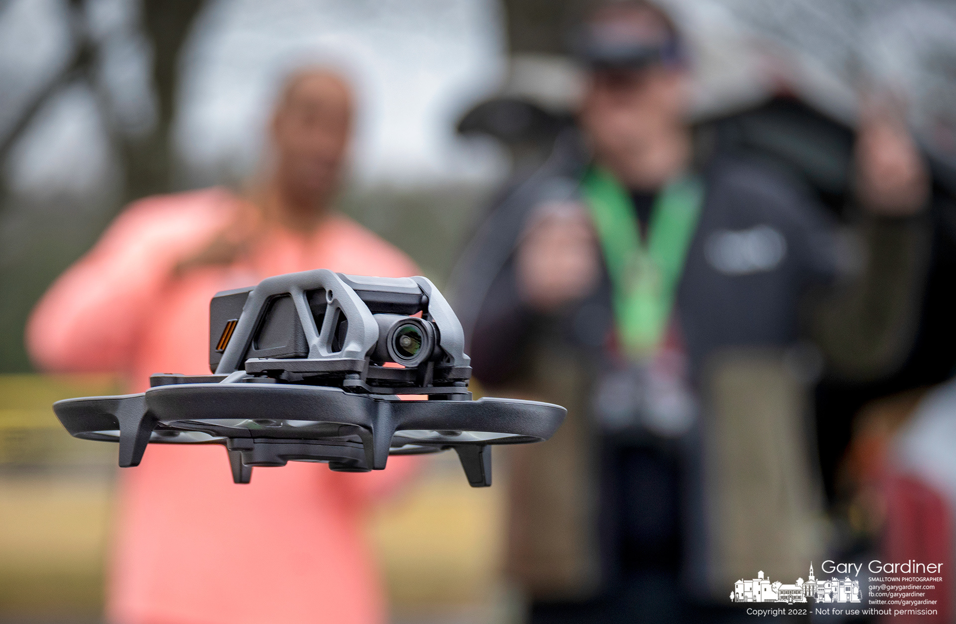 A drone pilot and his co-pilot study the flight characteristics of the new drone the pilot received for Christmas as it takes its first flight from the parking lot at an empty Highlands Park. My Final Photo for December 29, 2022.