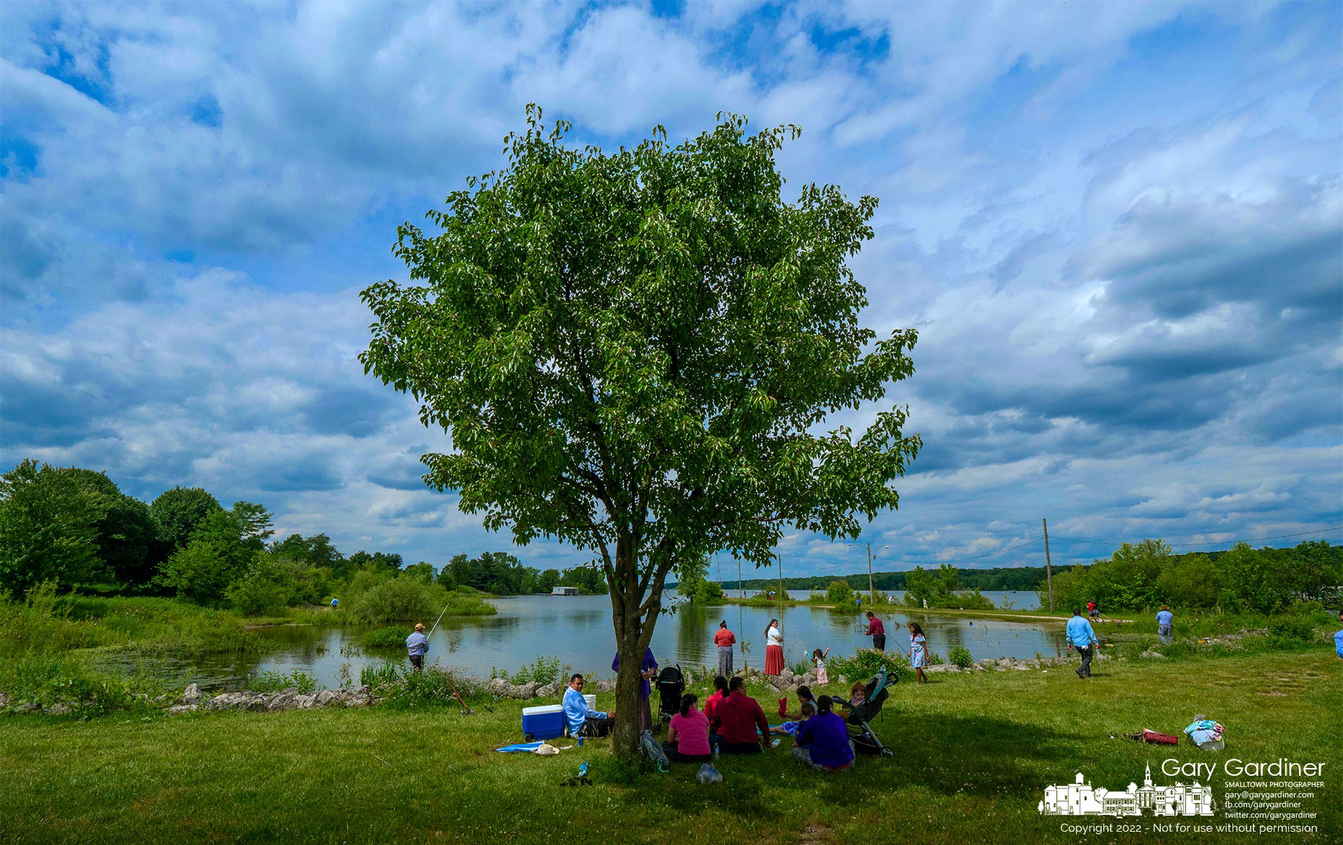 Family and friends gather in the shade of a tree on a bright afternoon to watch as part of their group take turns fishing in the small lagoon near the dam at Hoover Reservoir. My Final Photo for June 11, 2022.
