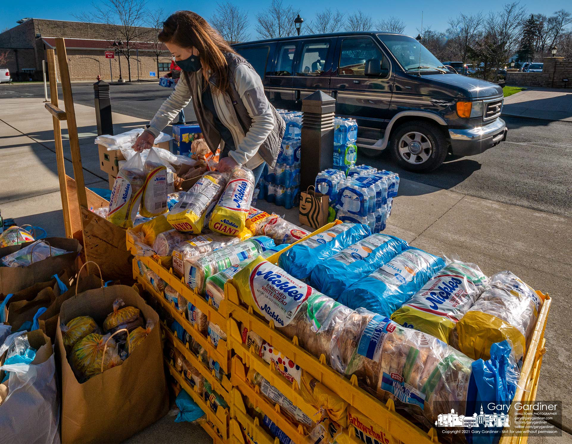 A volunteer helps sort stacks of sandwiches and other food items donated at St. Paul Catholic Church for food shelters in Columbus during Holy Week. My Final Photo for March 30, 2021.