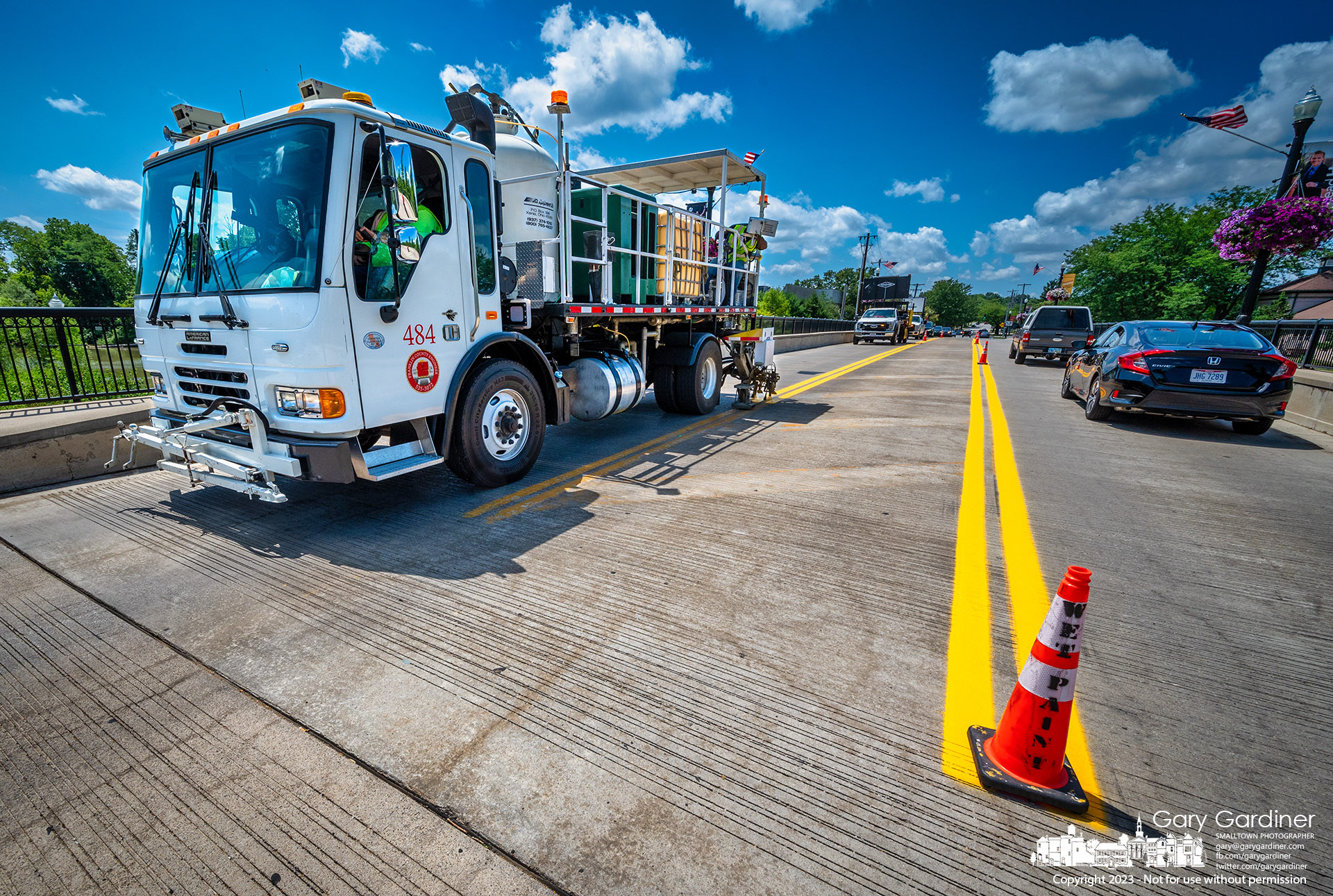 A Franklin County Engineer work crew paints lane striping on the Main Street Bridge following an earlier sealing of the structure surface. My Final Photo for August 8, 2023.